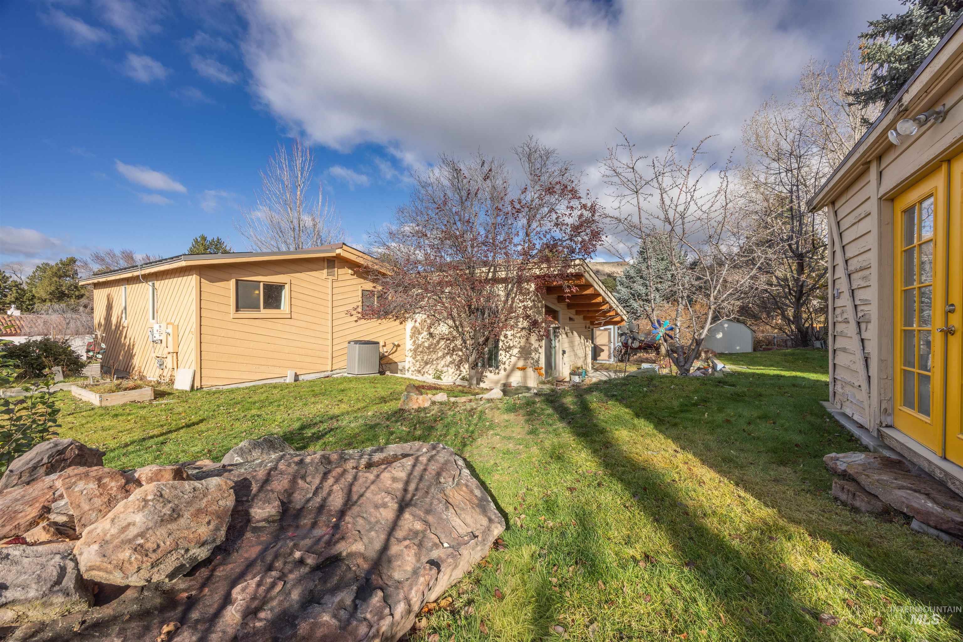 Back of house featuring an outbuilding and a lawn