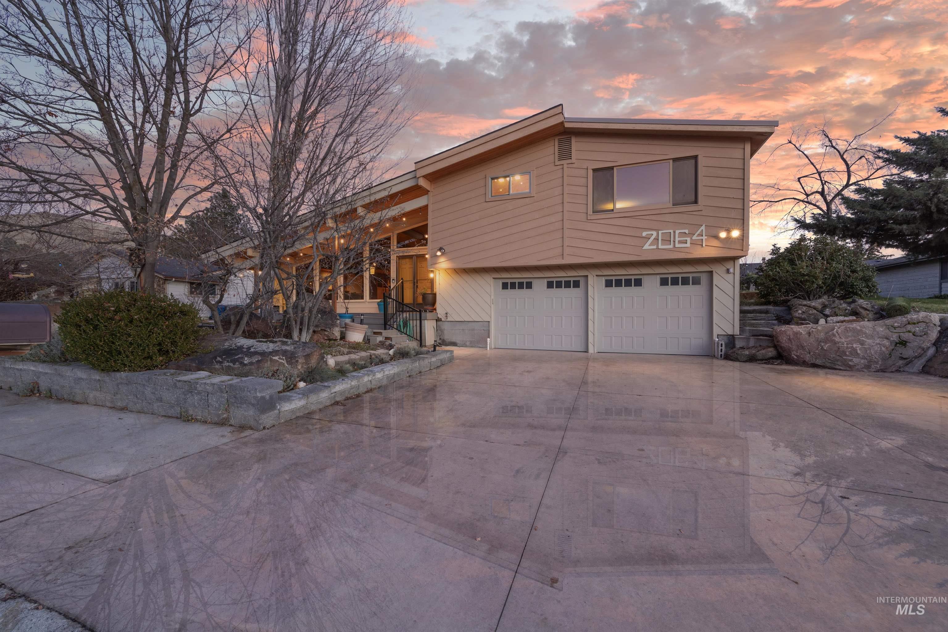View of front of property with concrete driveway and an attached garage