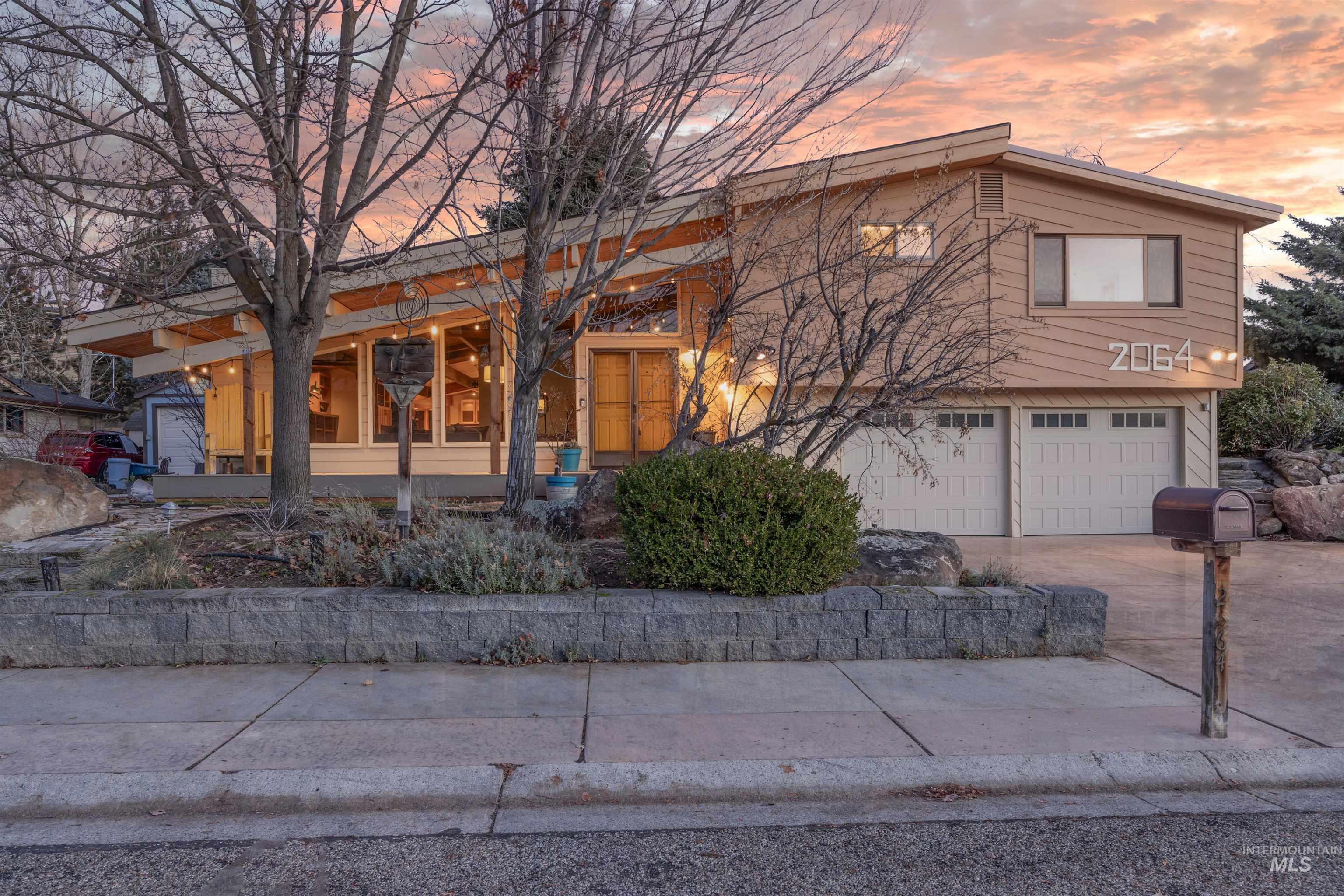 View of front of house with concrete driveway, covered porch, and a garage