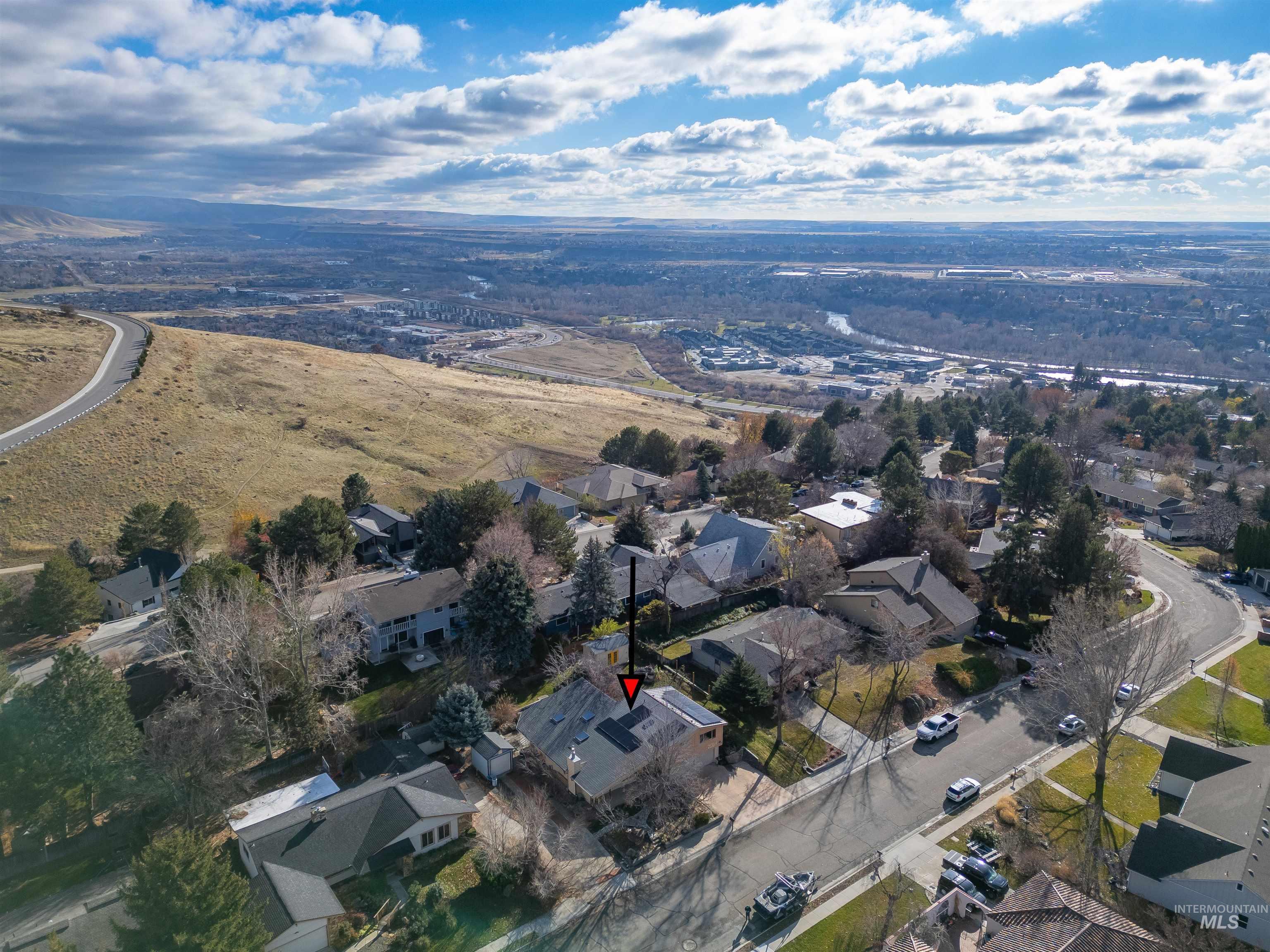 Aerial view of property and surrounding area with nearby suburban area