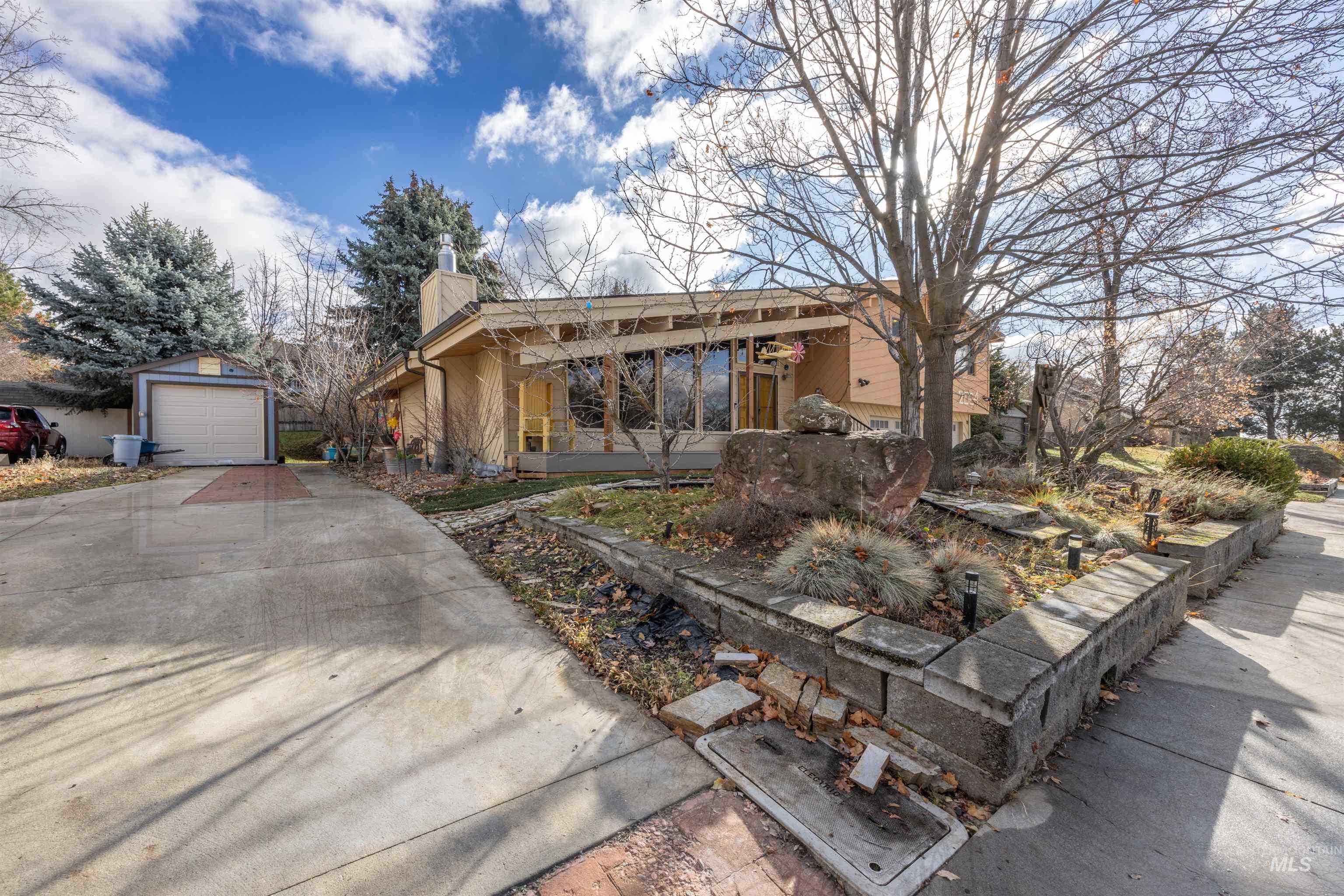 Single story home with an outbuilding, a chimney, and concrete driveway
