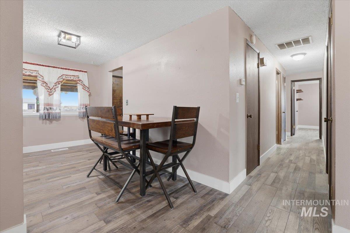 Dining area featuring a textured ceiling and light wood finished floors