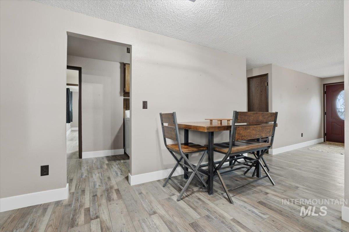 Dining room with a textured ceiling and light wood finished floors