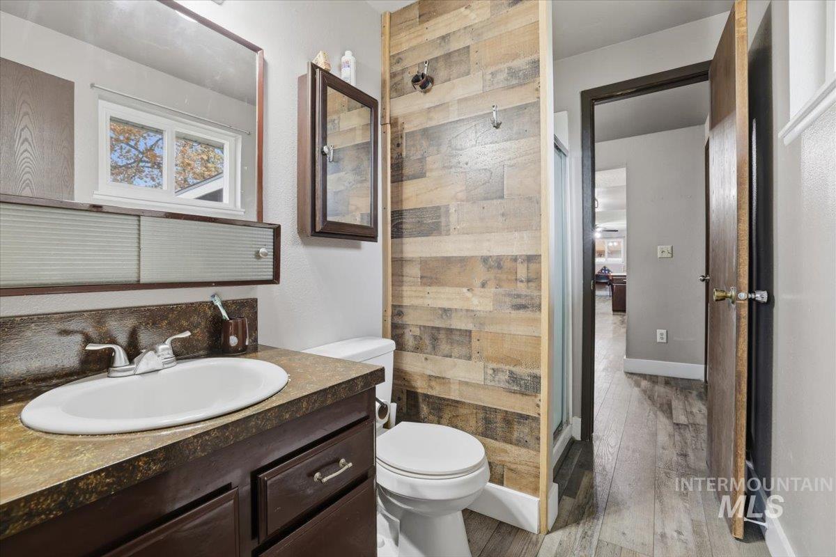 Bathroom with vanity, a stall shower, and light wood-type flooring