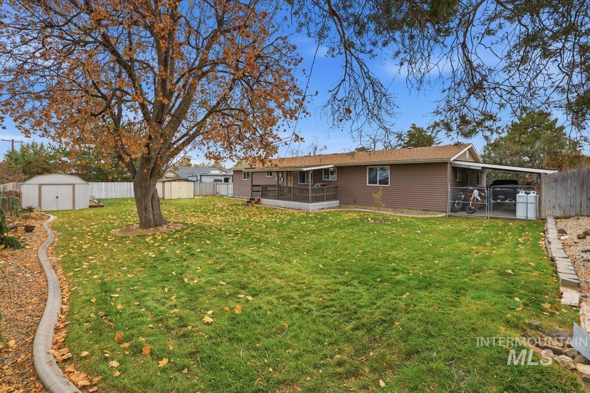 Back of property with a fenced backyard, a storage shed, a sunroom, and a gate