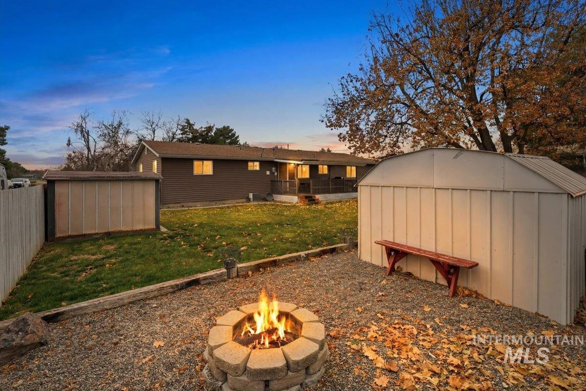 Rear view of property with a storage unit and a yard