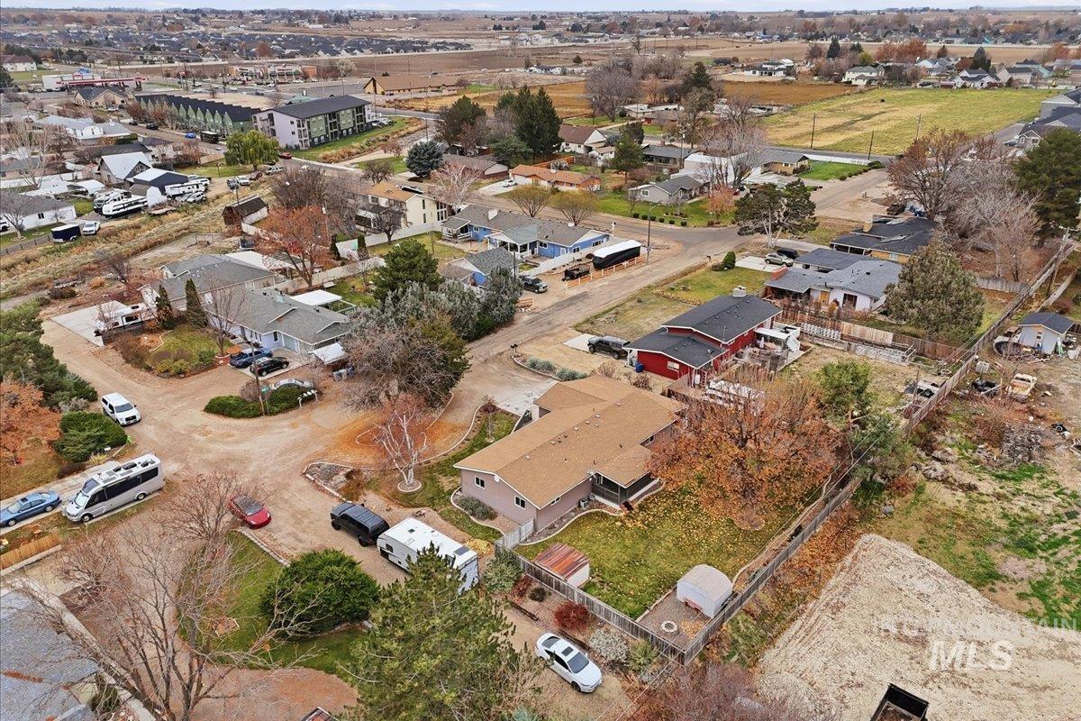 Aerial view of property and surrounding area featuring nearby suburban area