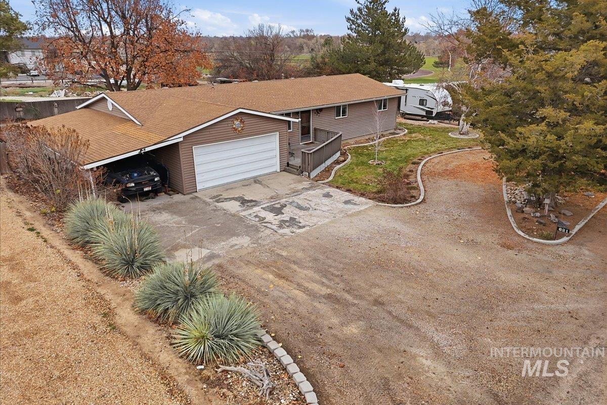 View of front of house featuring concrete driveway, a shingled roof, and a garage