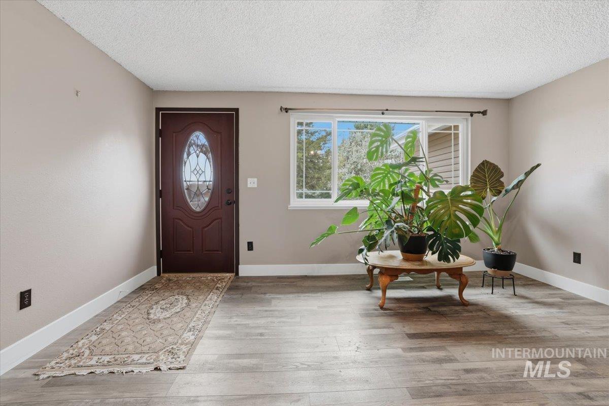 Foyer entrance with a textured ceiling and light wood finished floors