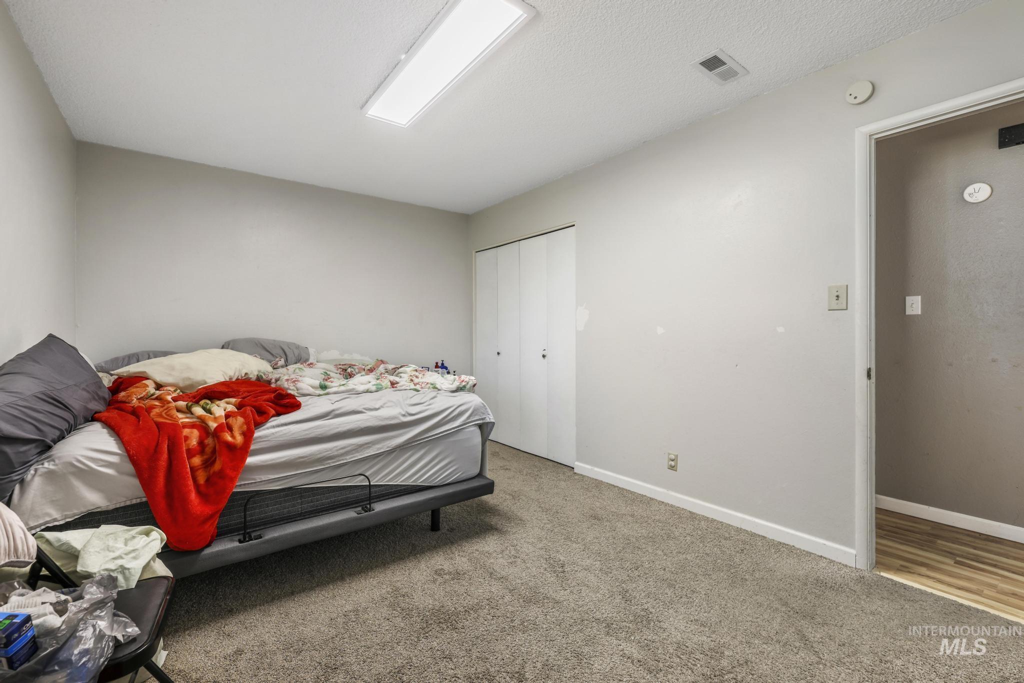 Carpeted bedroom featuring a closet and a textured ceiling