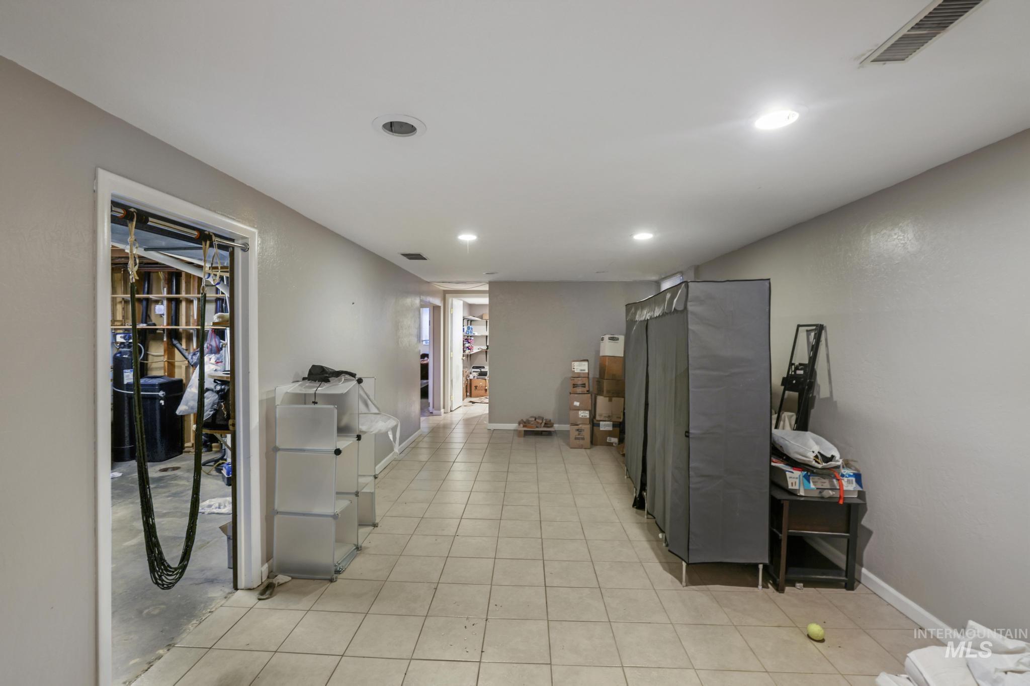 Corridor with light tile patterned floors and recessed lighting