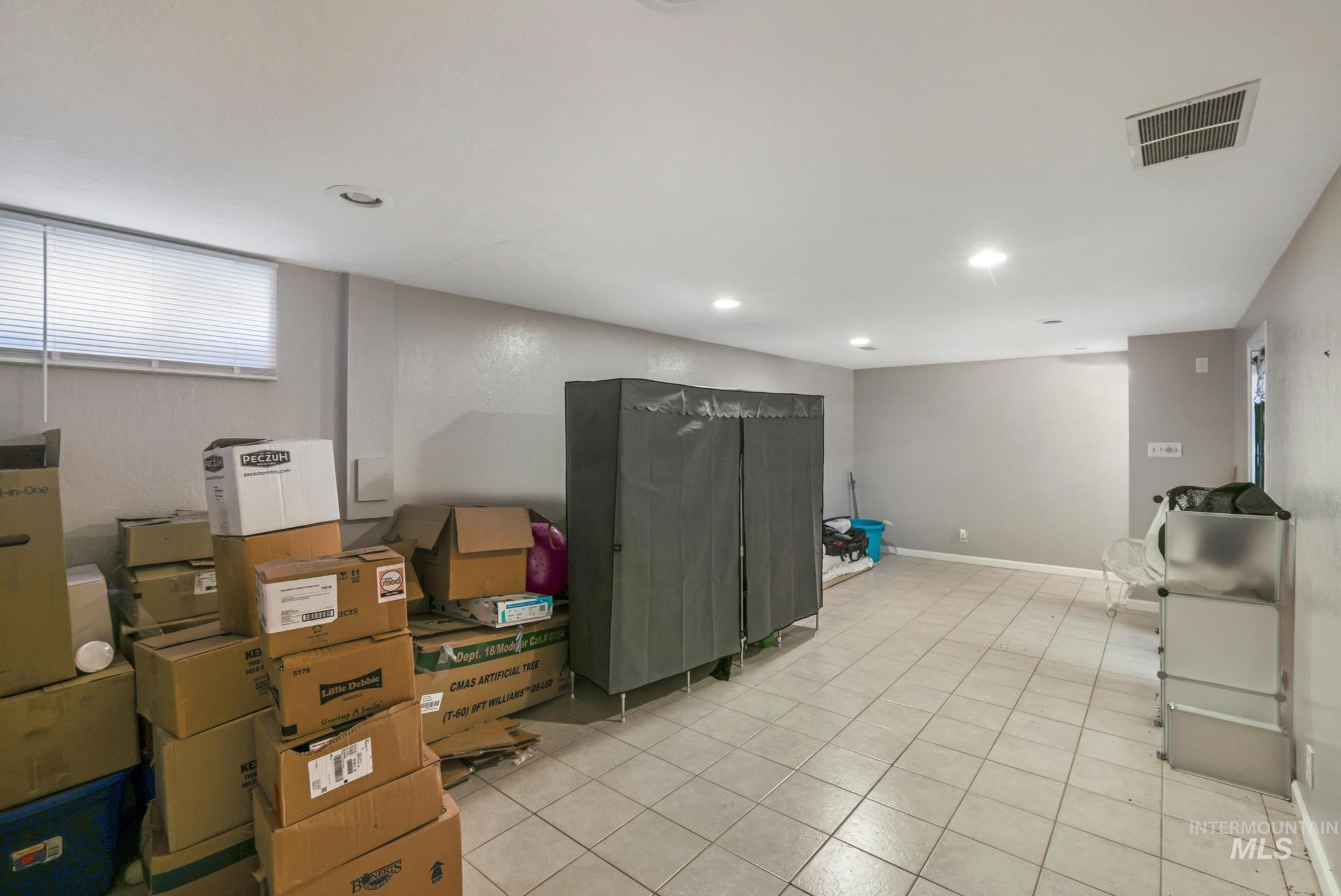 Below grade area with light tile patterned floors and baseboards