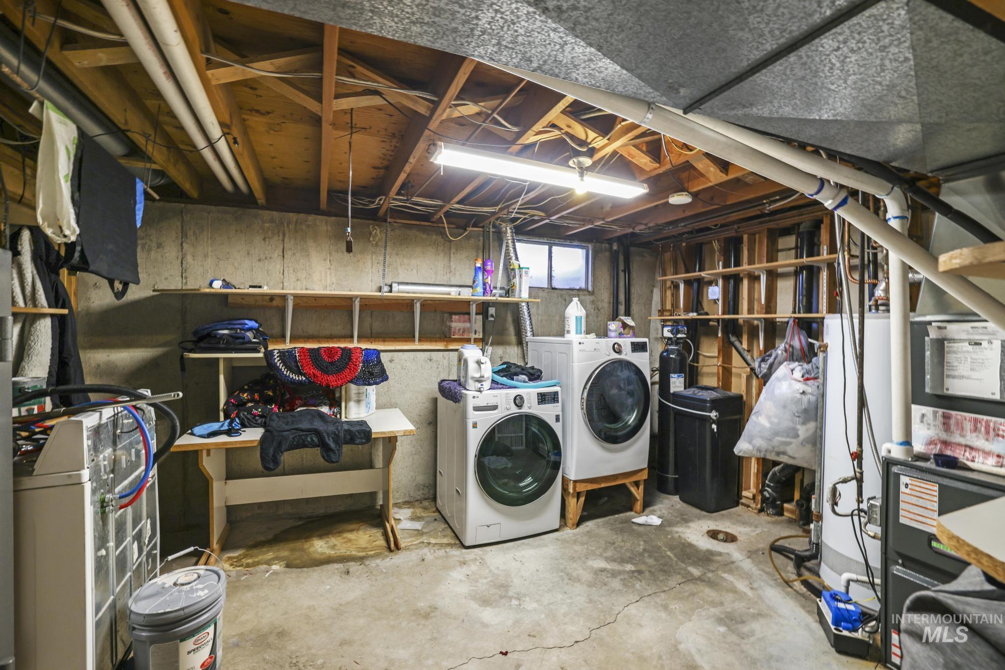 Below grade area featuring independent washer and dryer, a water softener, and water heater