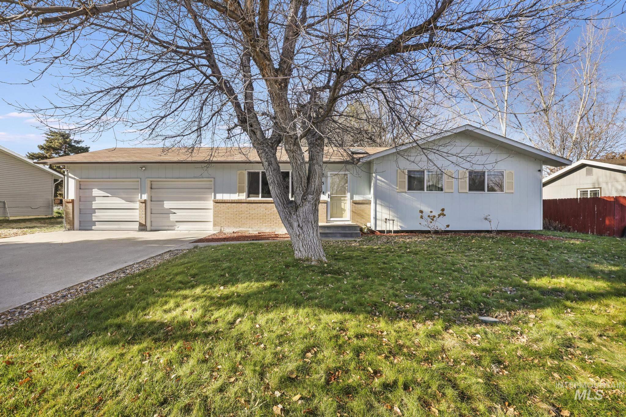 Ranch-style home featuring brick siding, driveway, and an attached garage