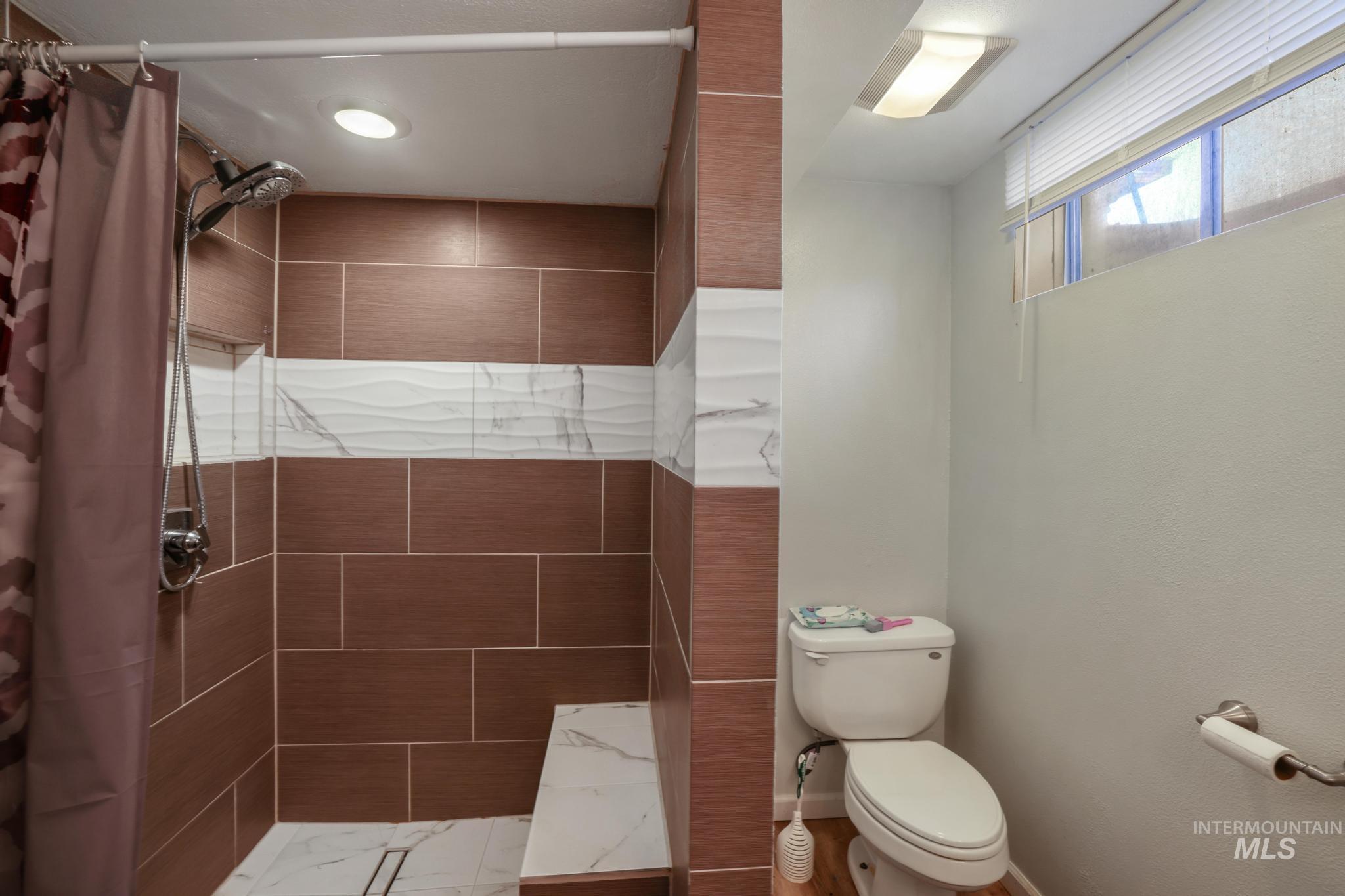 Bathroom with a stall shower and toilet