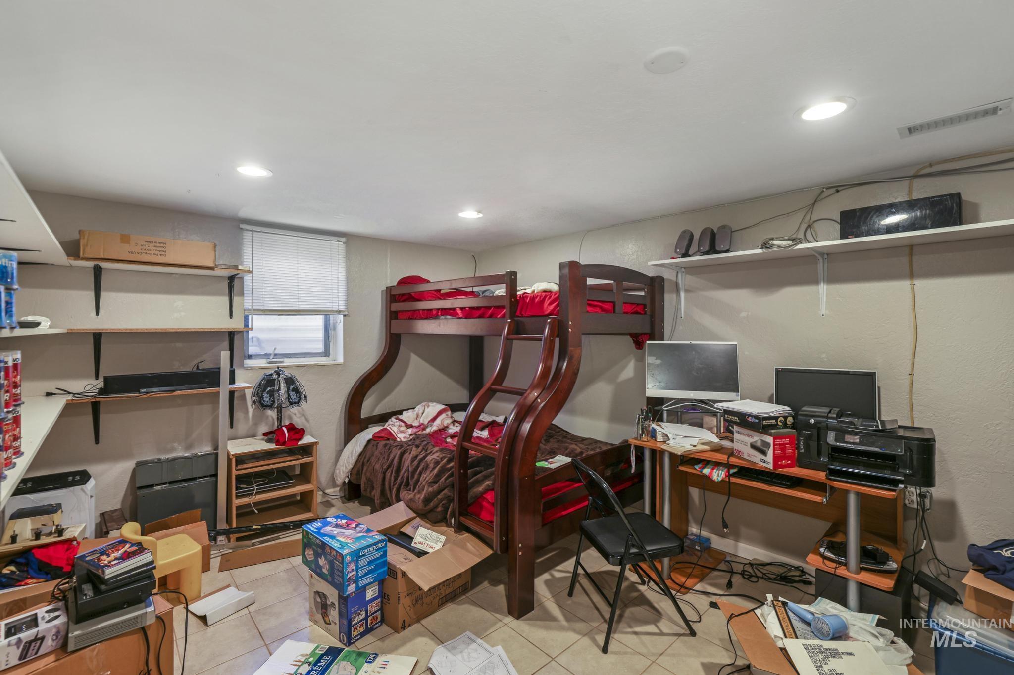 Bedroom featuring light tile patterned flooring, recessed lighting, and a desk