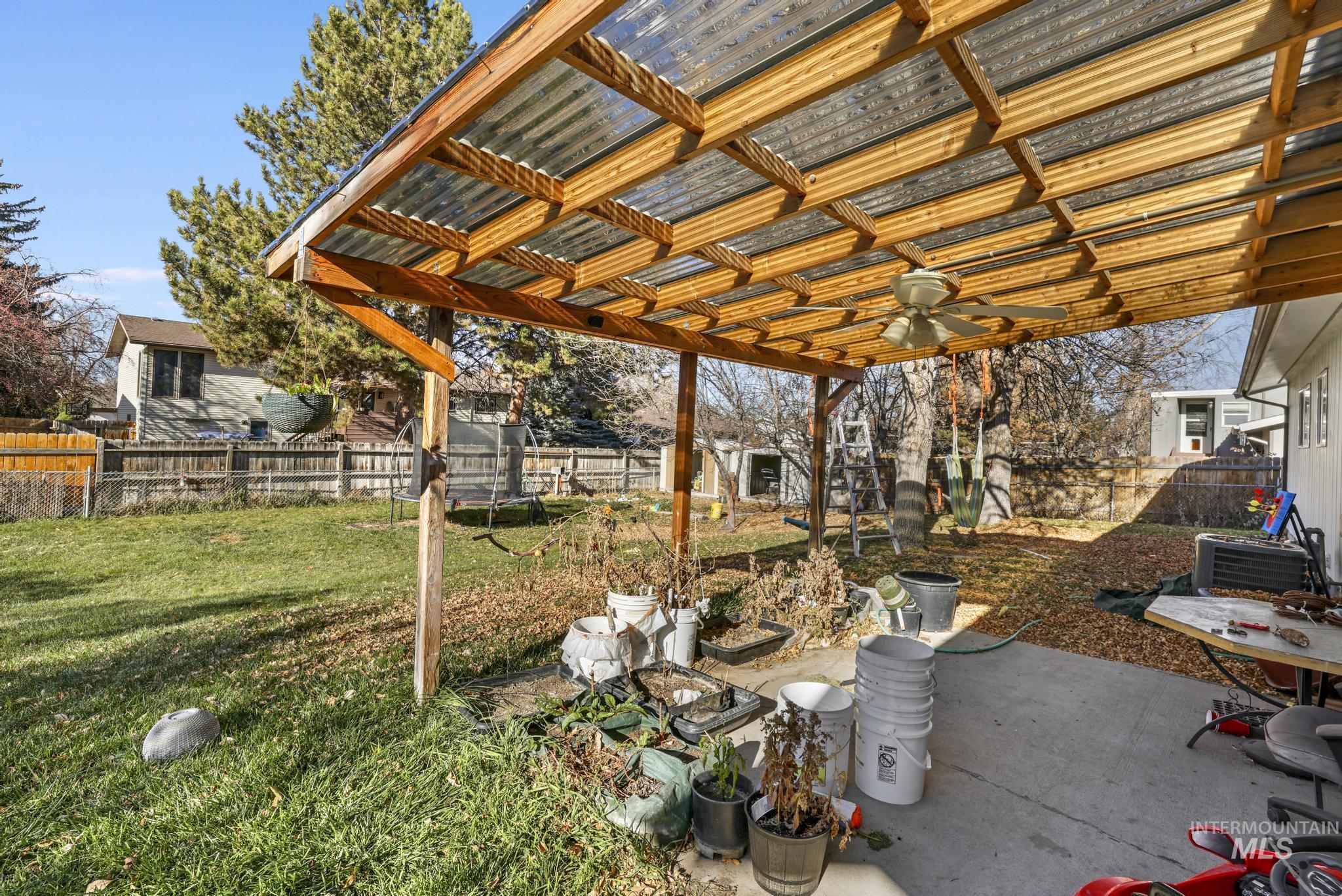 Fenced backyard with a patio area and ceiling fan