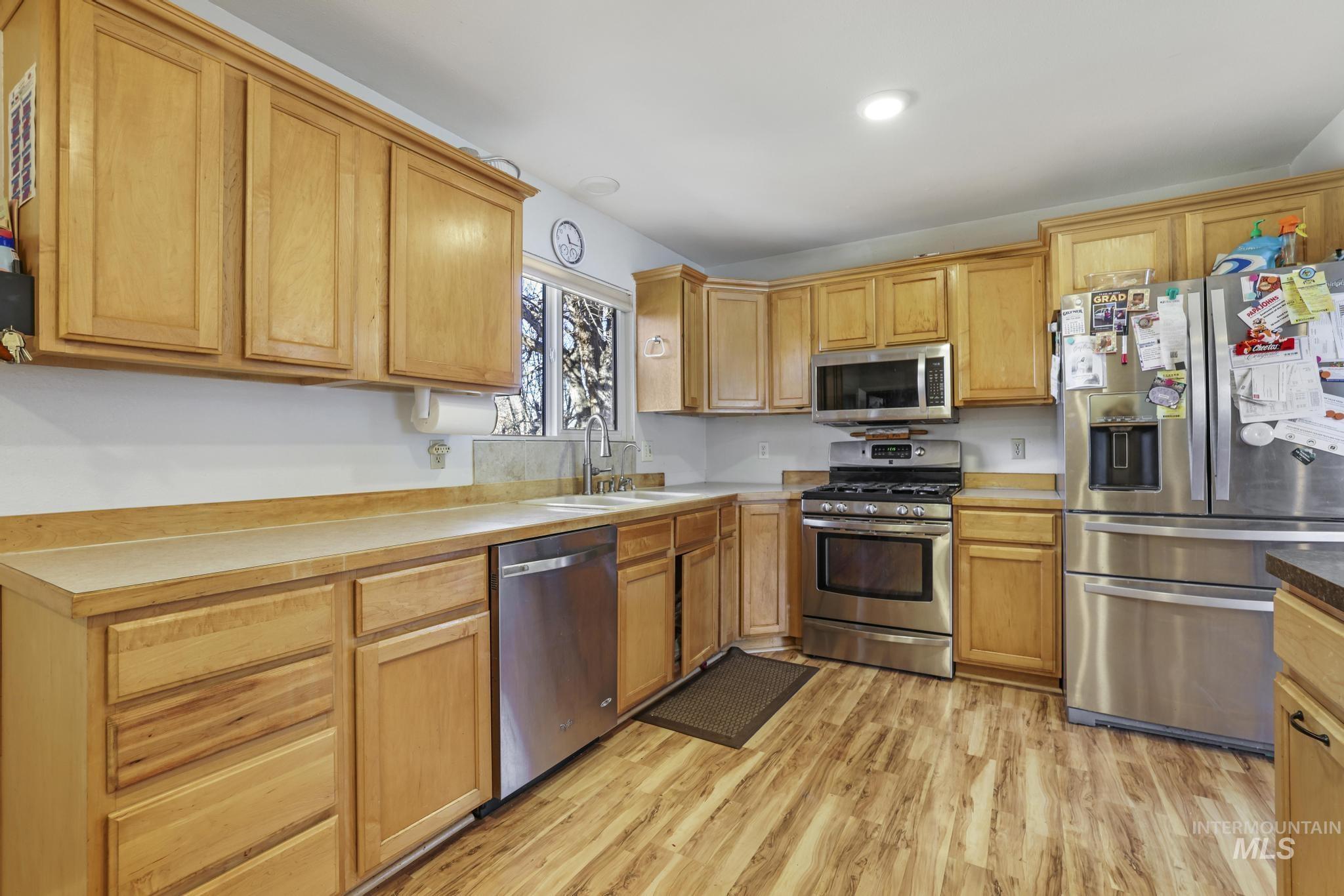 Kitchen featuring stainless steel appliances, light wood finished floors, and light countertops