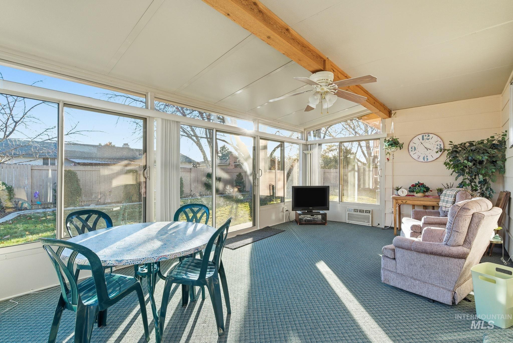 Sunroom / solarium featuring ceiling fan and outdoor dining area