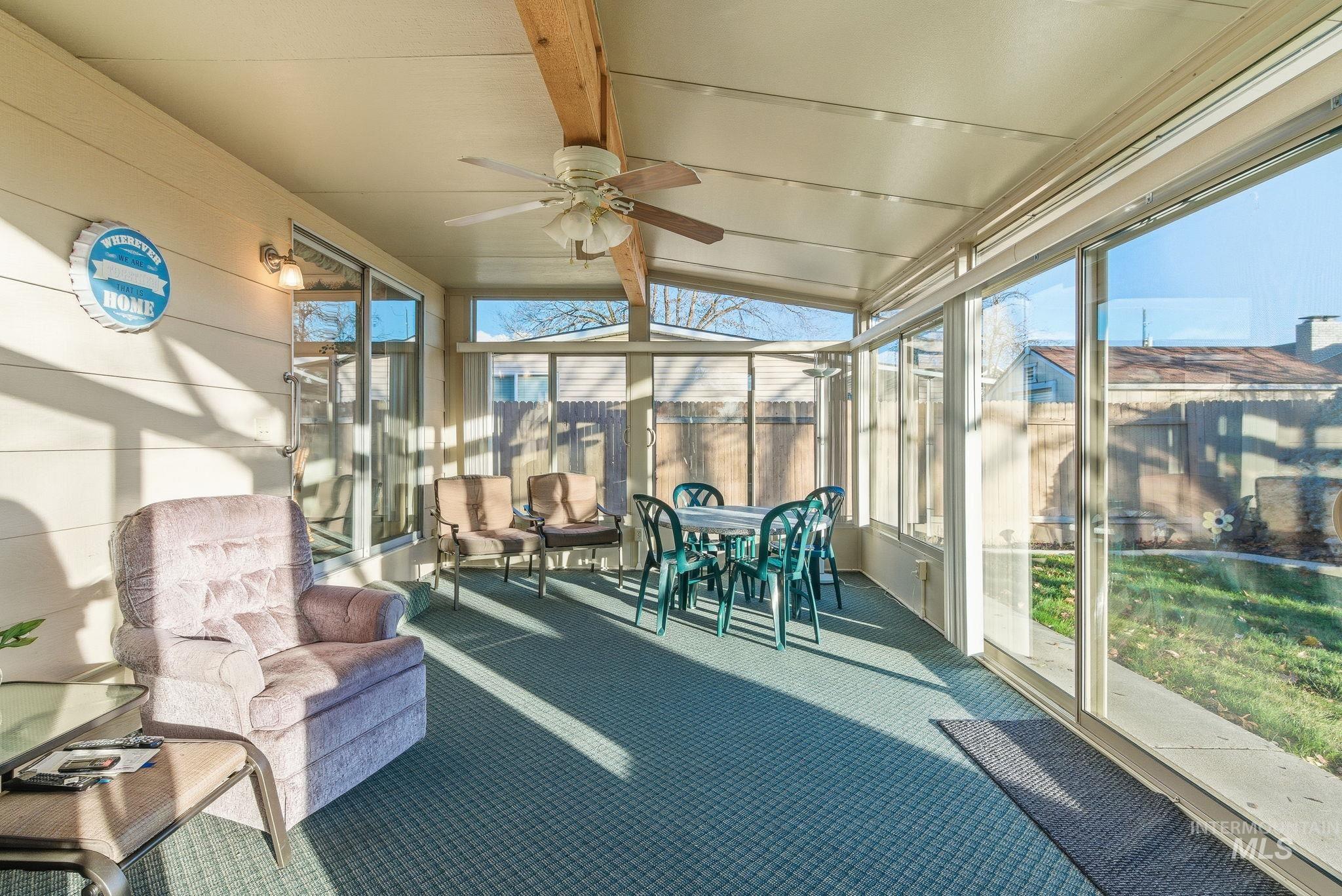 Sunroom featuring a ceiling fan, outdoor dining area, and outdoor lounge area