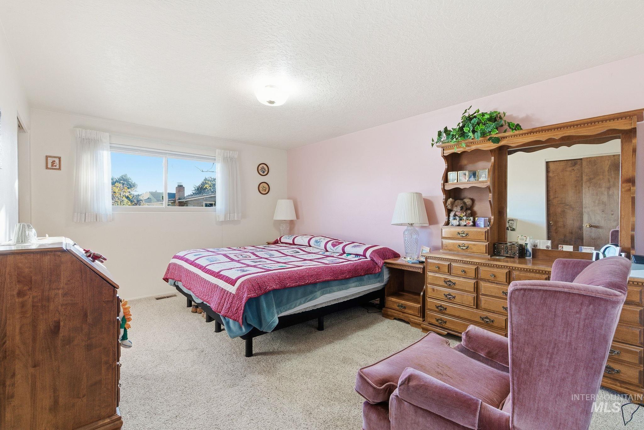 Bedroom with carpet floors and a textured ceiling