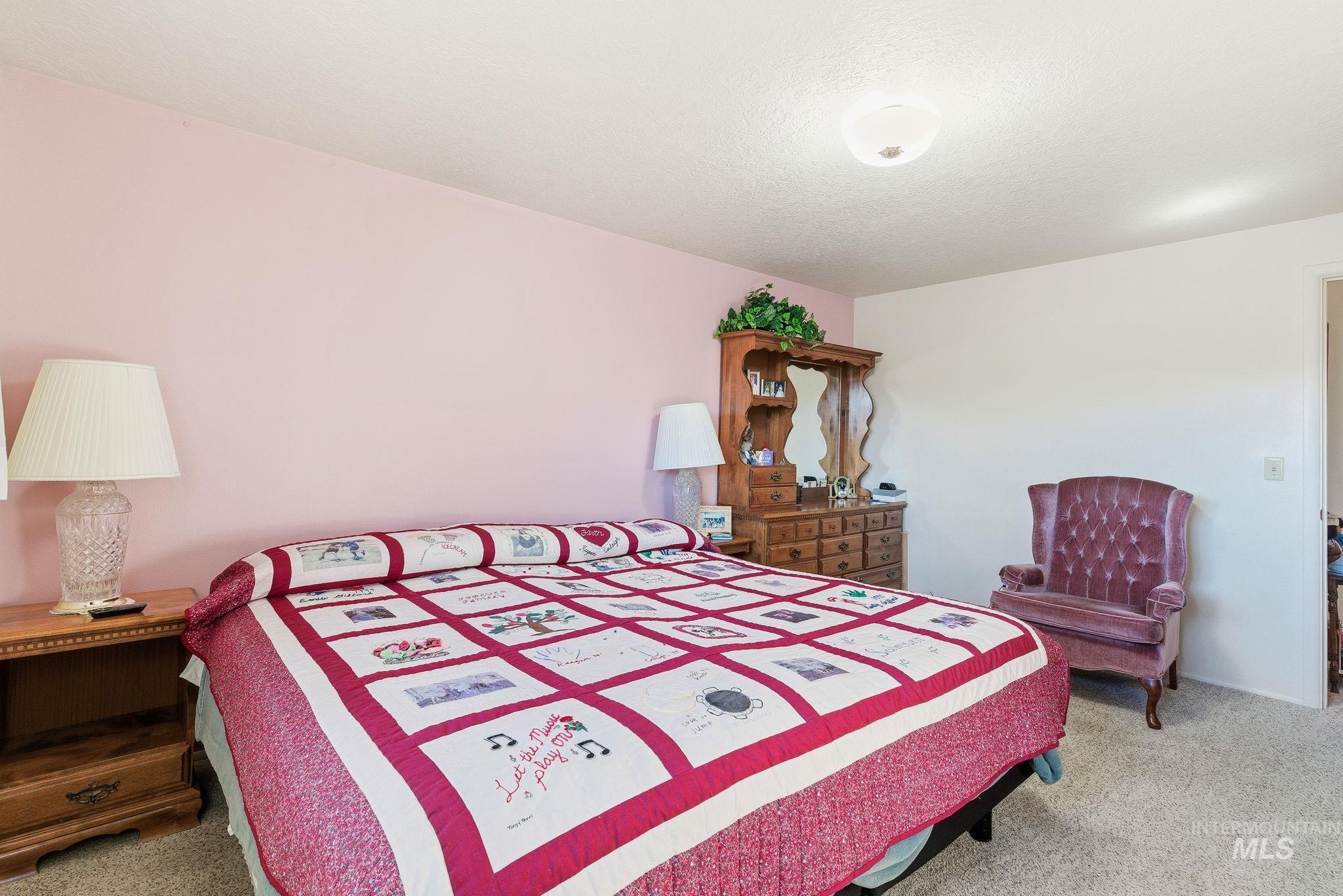Bedroom with light carpet and a textured ceiling