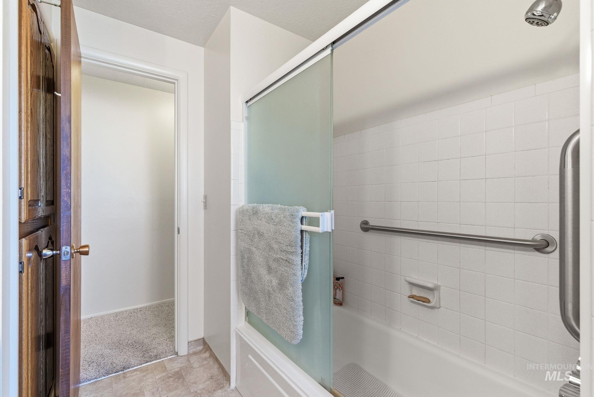 Bathroom featuring enclosed tub / shower combo