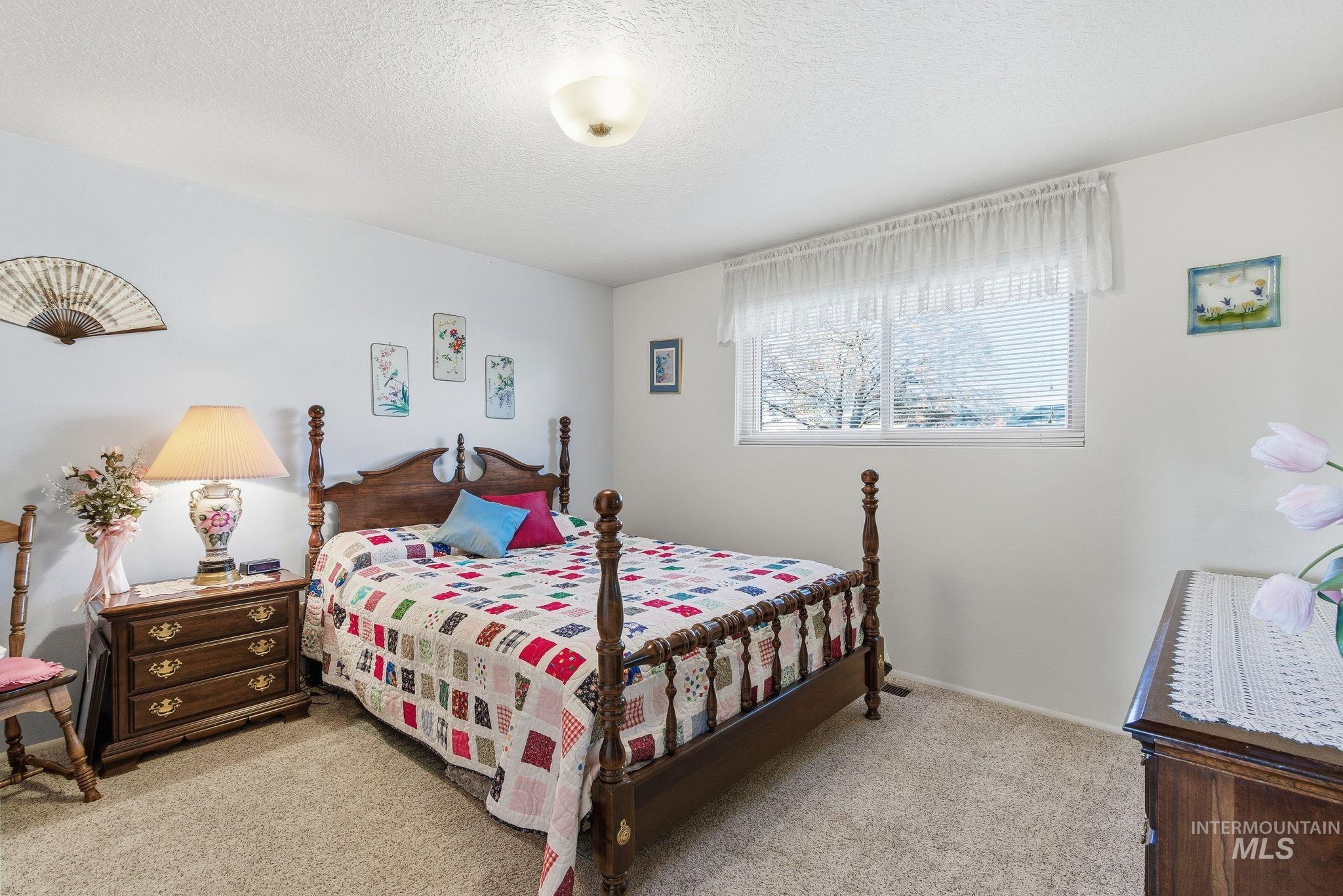 Bedroom featuring a textured ceiling and carpet flooring