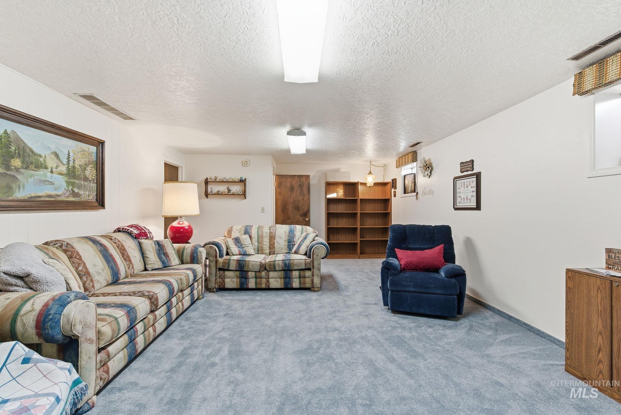 Living room featuring a textured ceiling and carpet flooring
