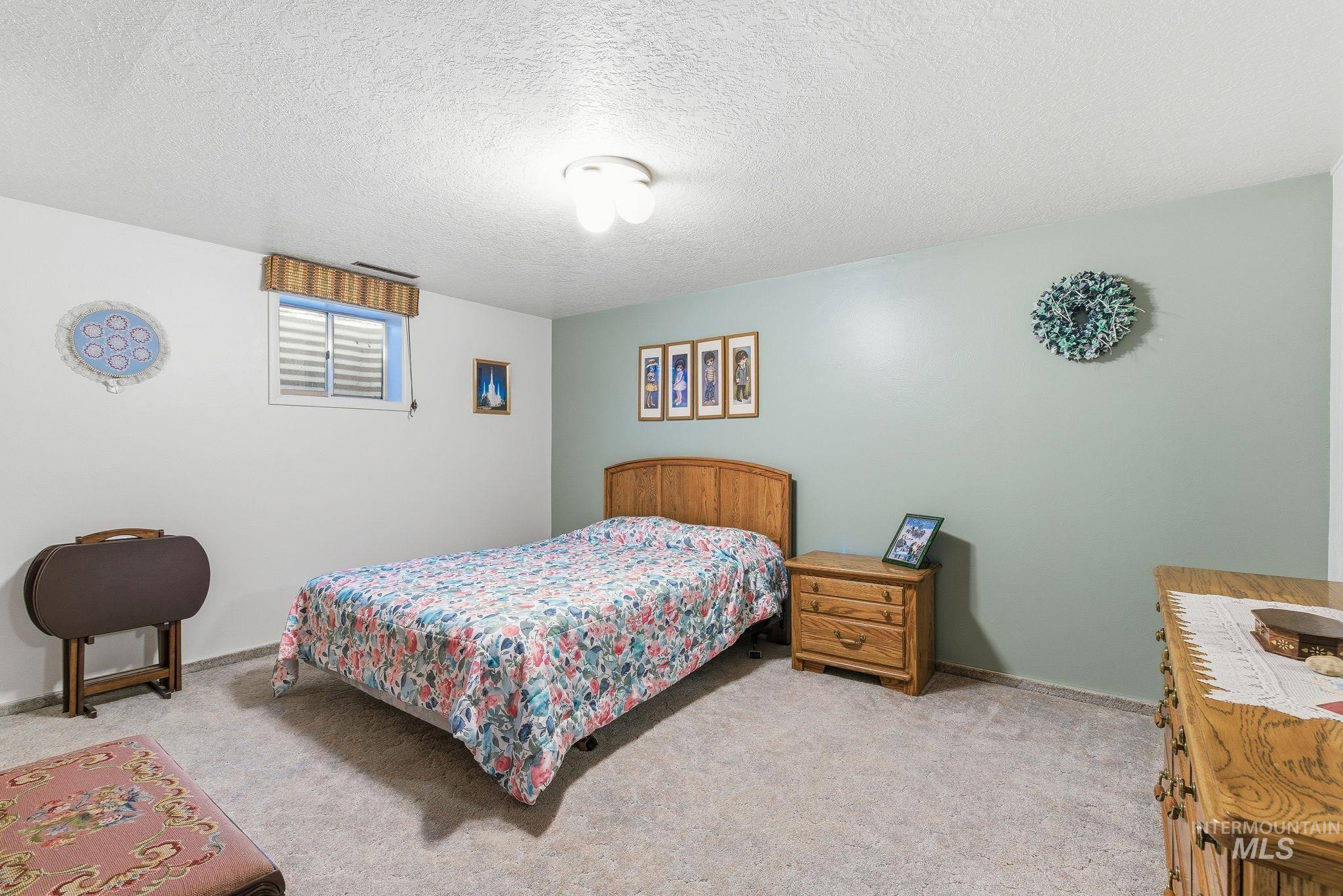Bedroom featuring a textured ceiling and carpet floors