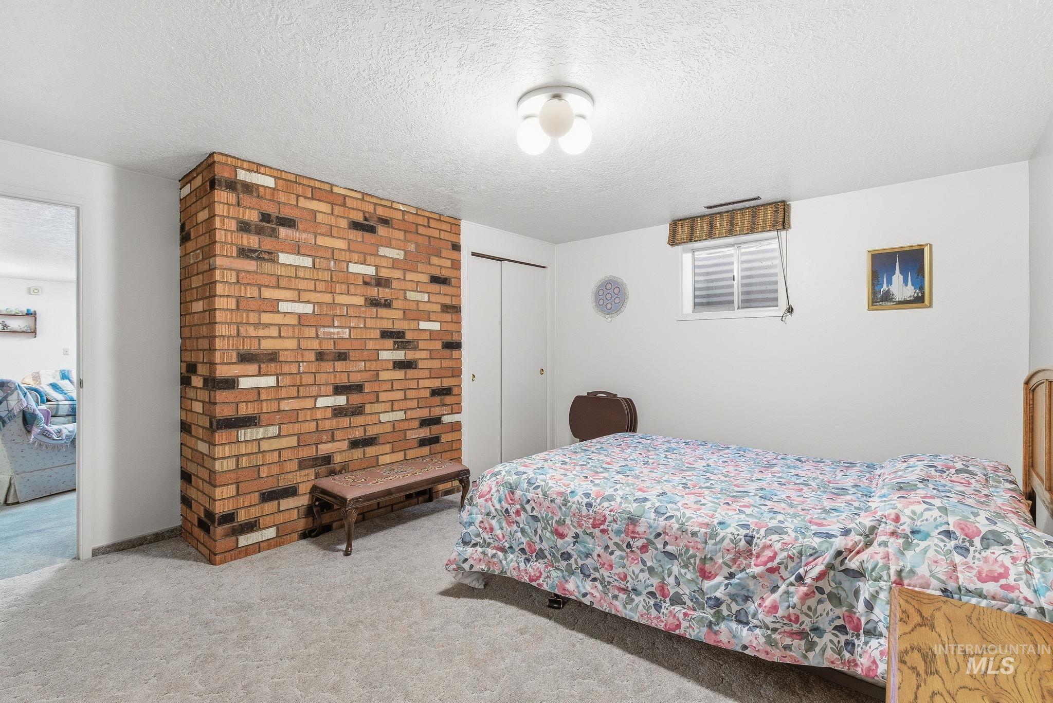 Bedroom with carpet flooring, a textured ceiling, and a closet