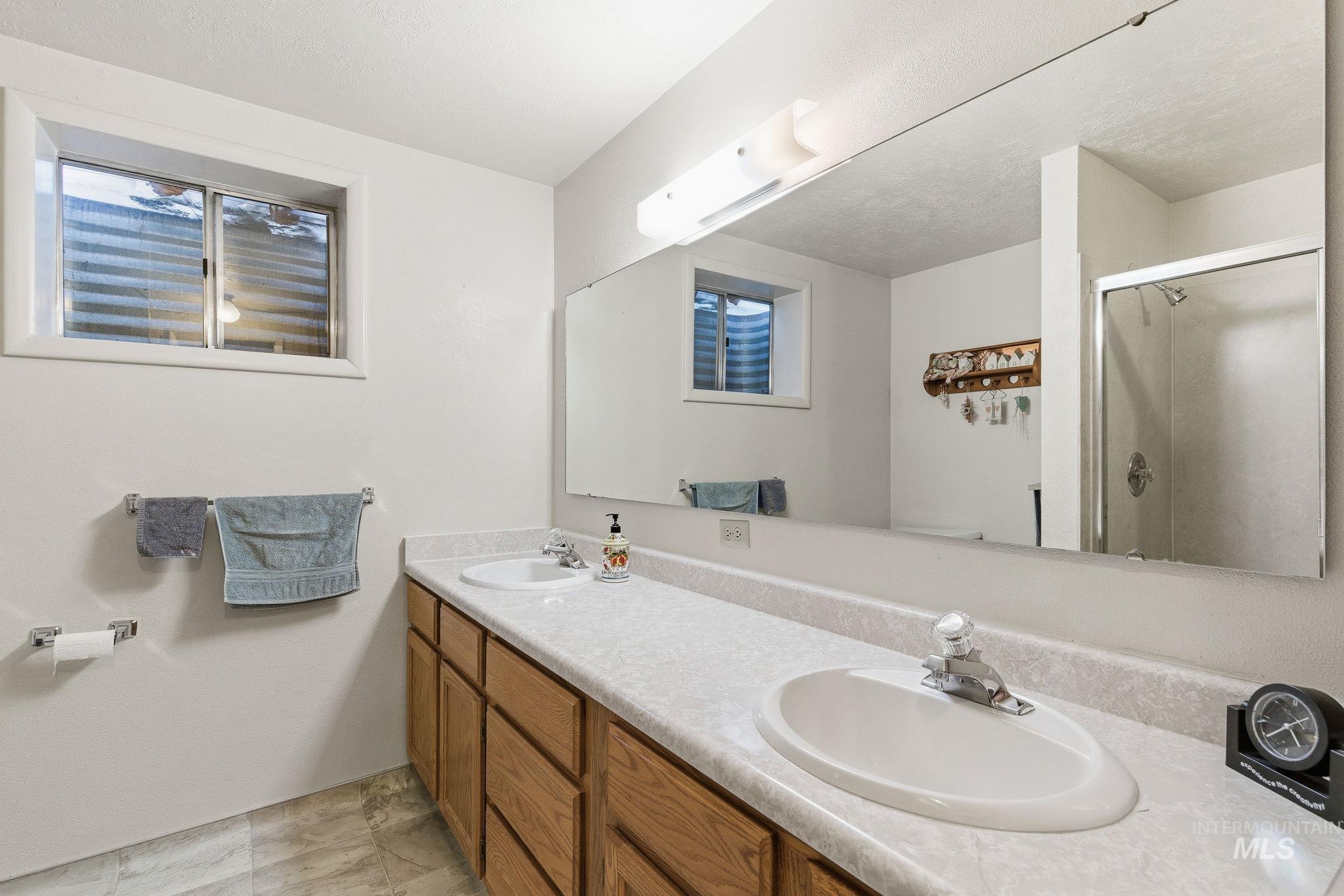 Bathroom featuring double vanity and a shower stall