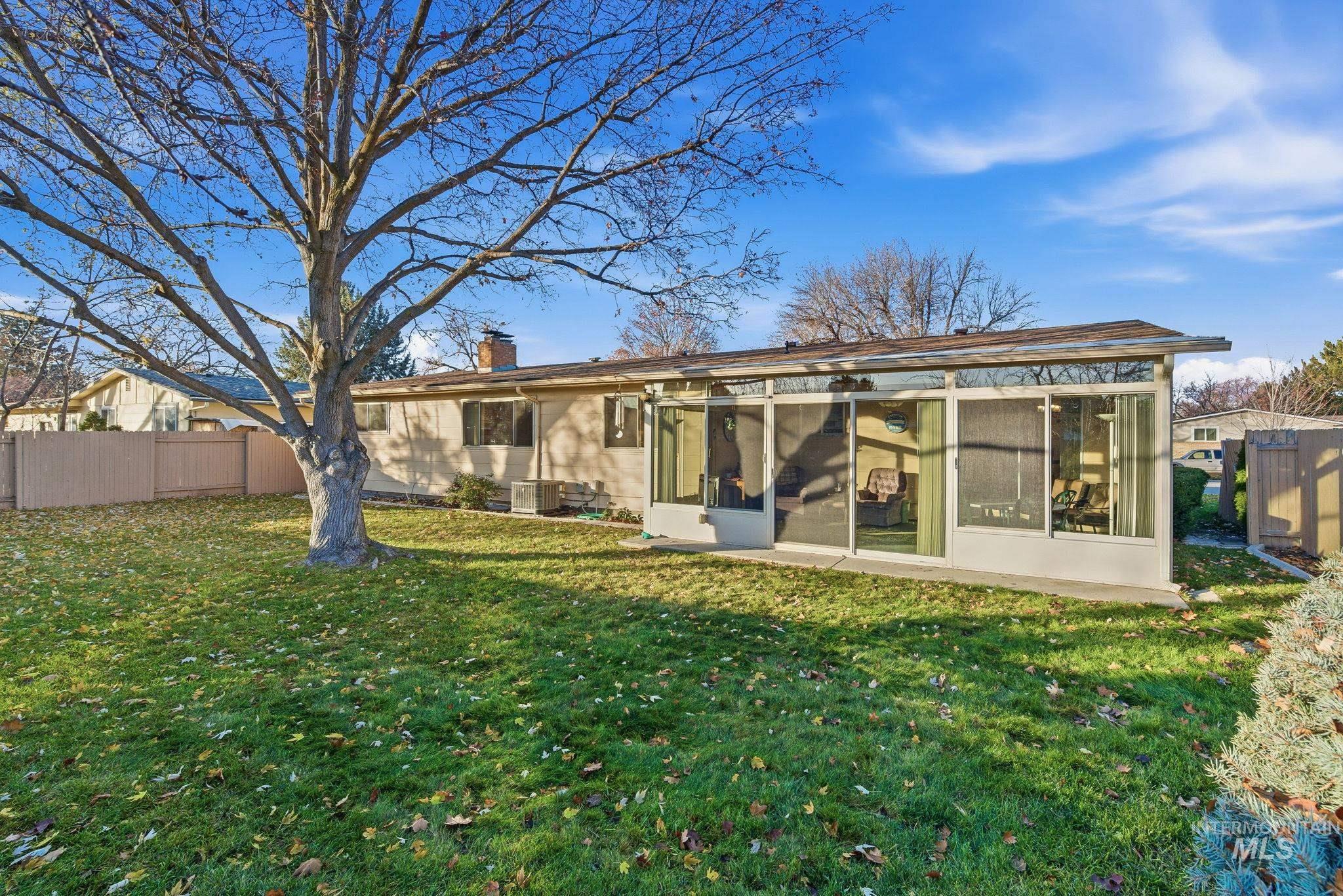 Rear view of house with a chimney and a sunroom