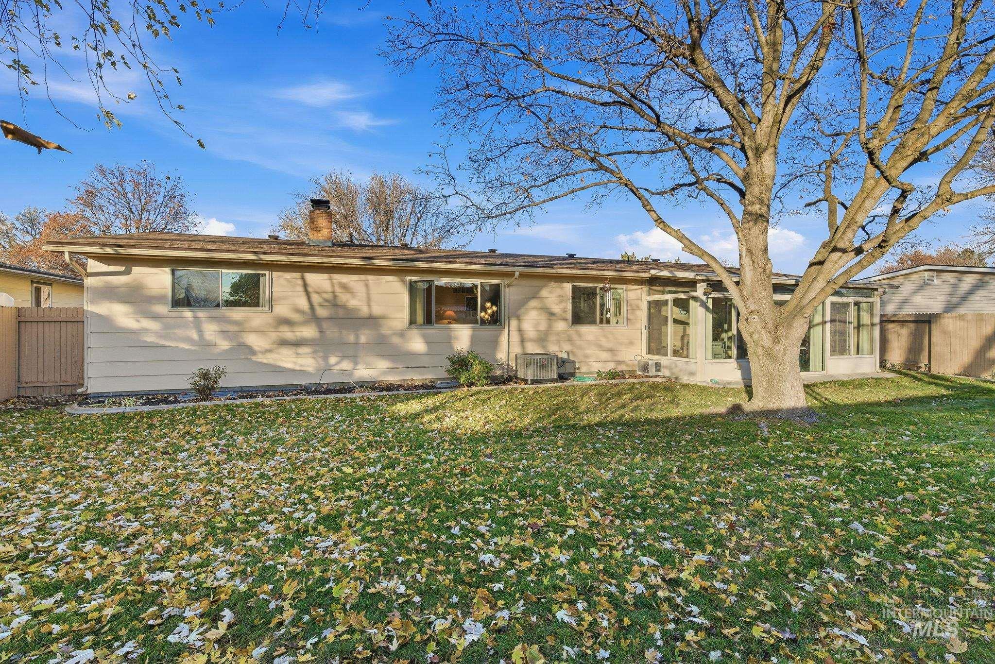 Back of property with a sunroom and a chimney