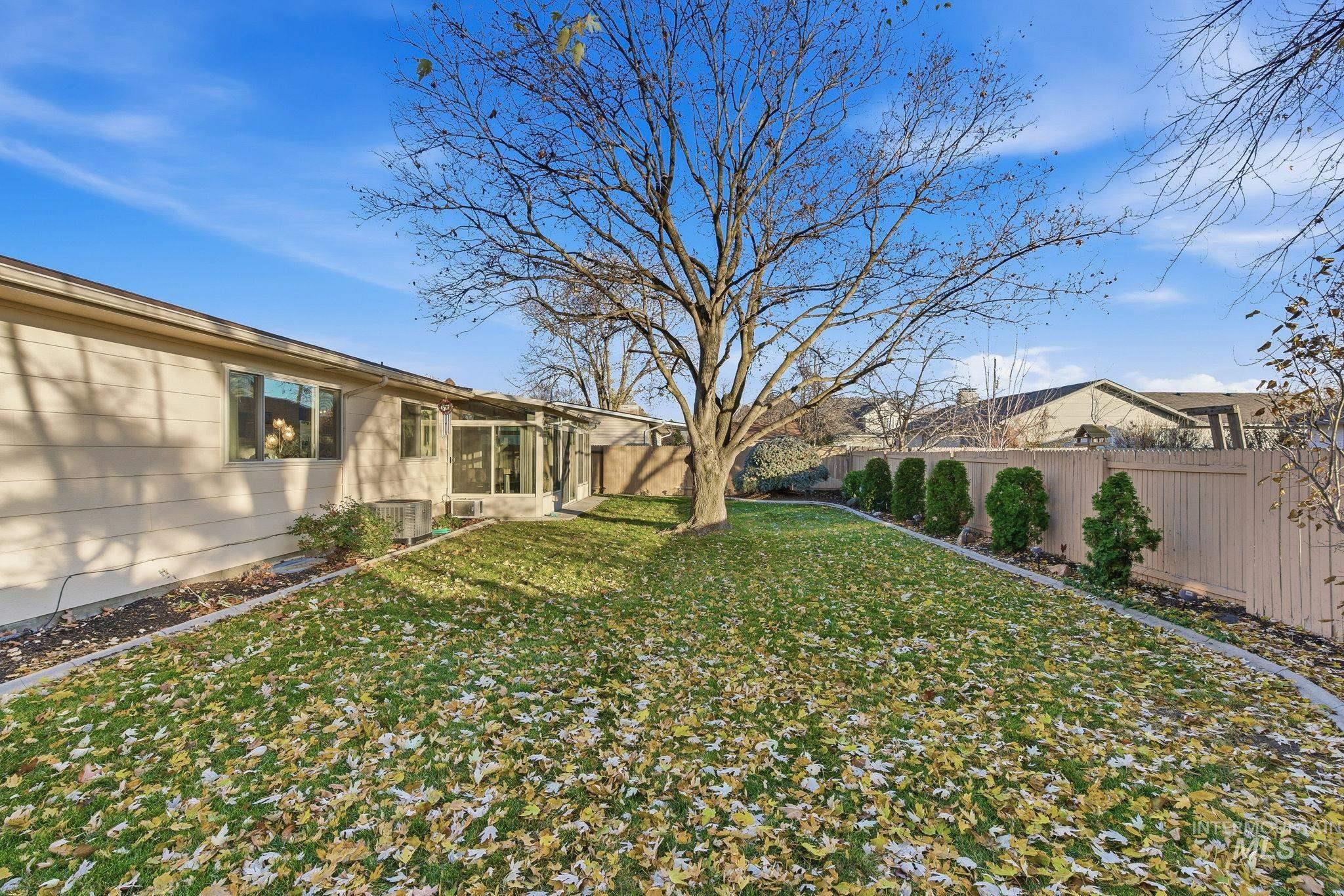 Fenced backyard featuring a sunroom