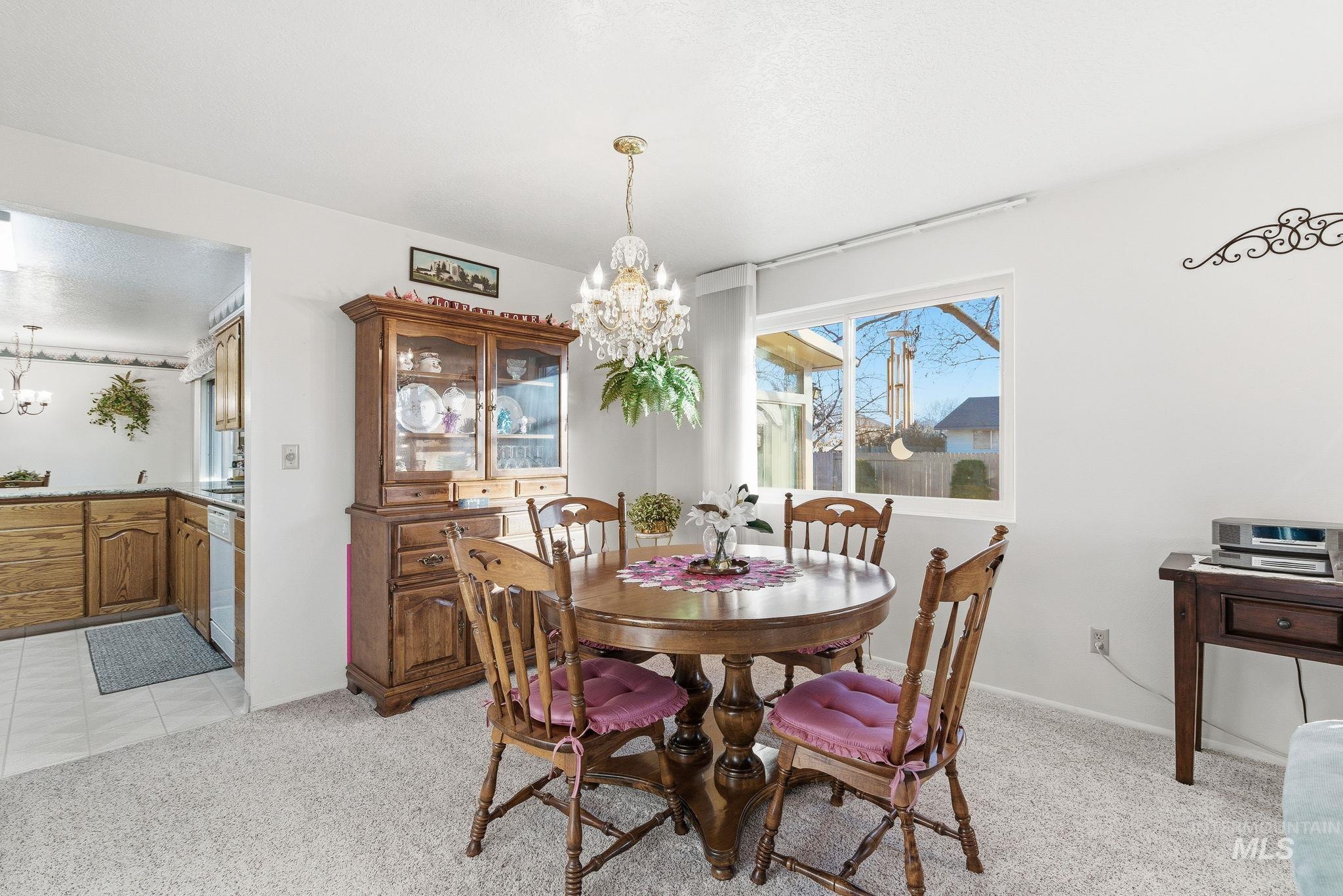 Dining area featuring a chandelier and light colored carpet