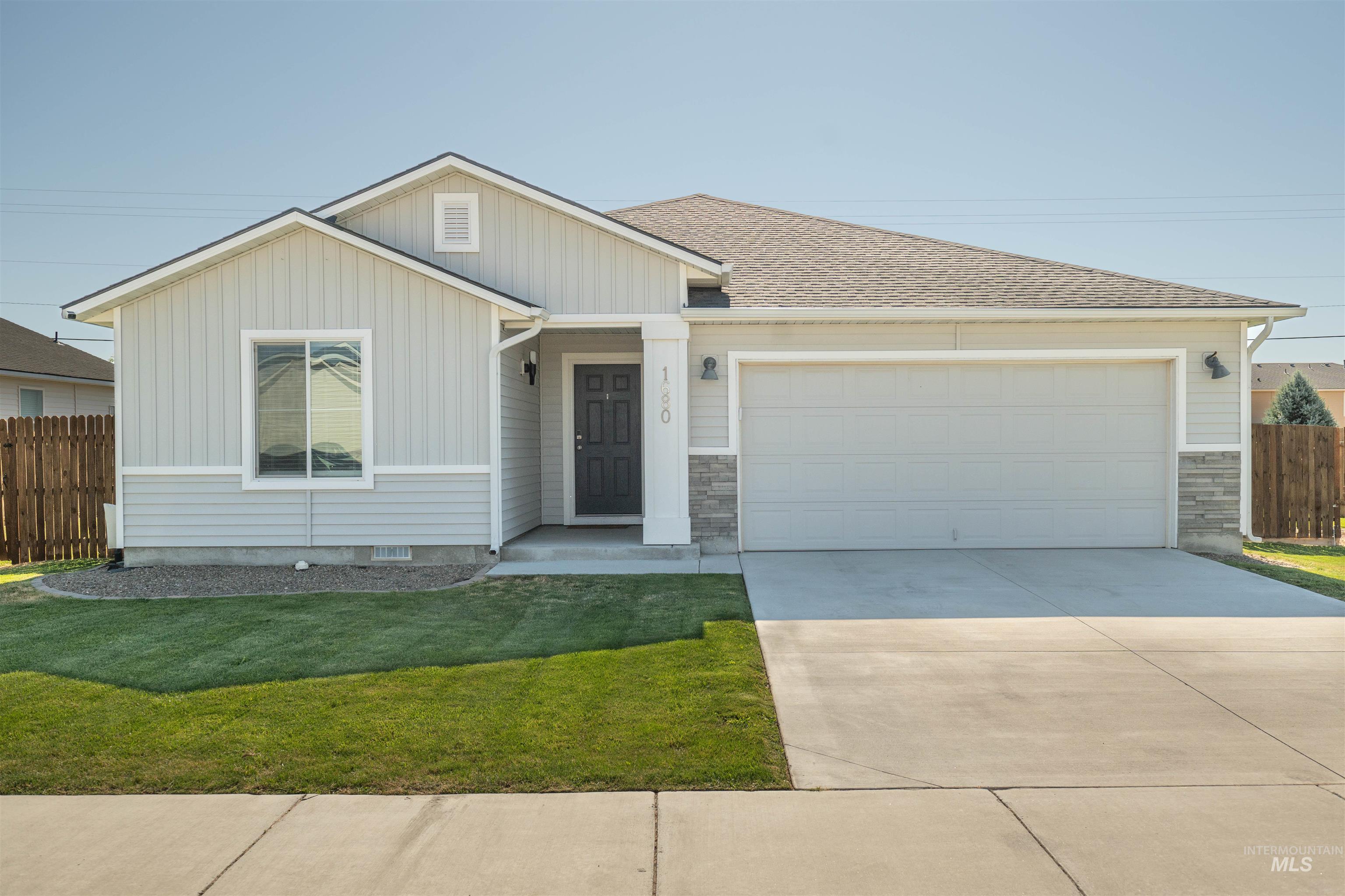 View of front of home with a garage, board and batten siding, concrete driveway, a shingled roof, and stone siding