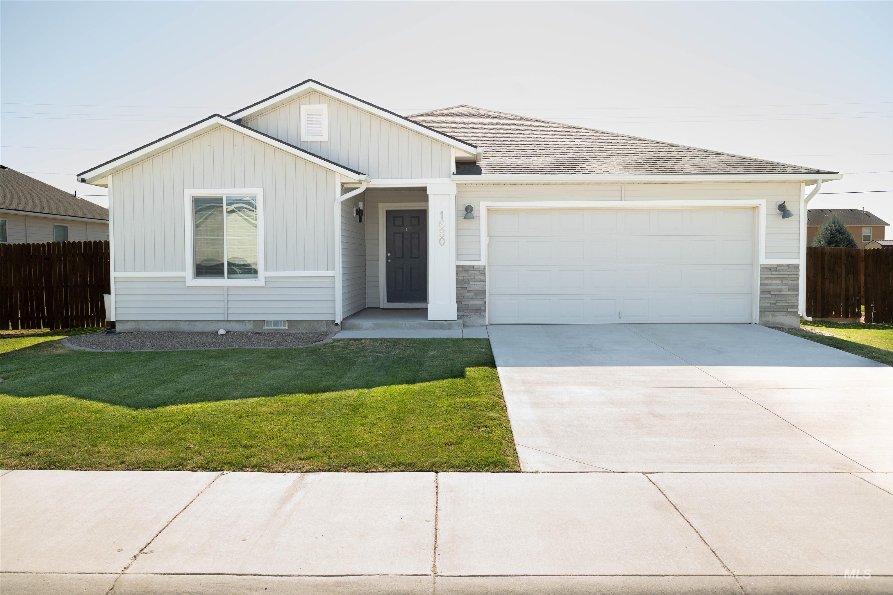 Ranch-style home with board and batten siding, a garage, driveway, and a shingled roof
