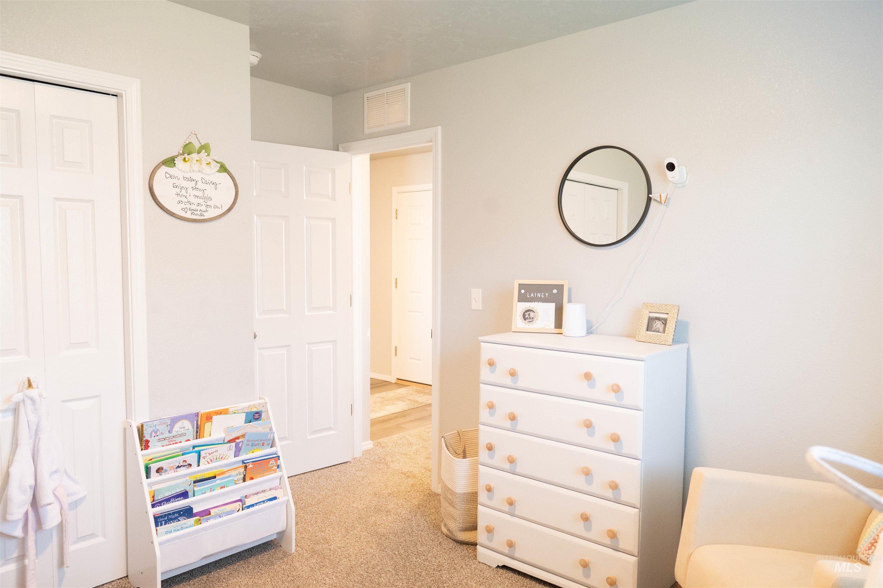 Bedroom featuring light colored carpet and a closet
