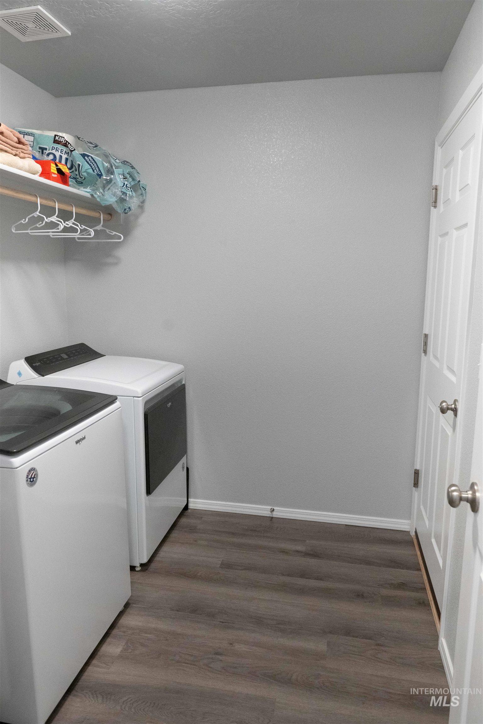 Laundry area featuring independent washer and dryer and dark wood finished floors