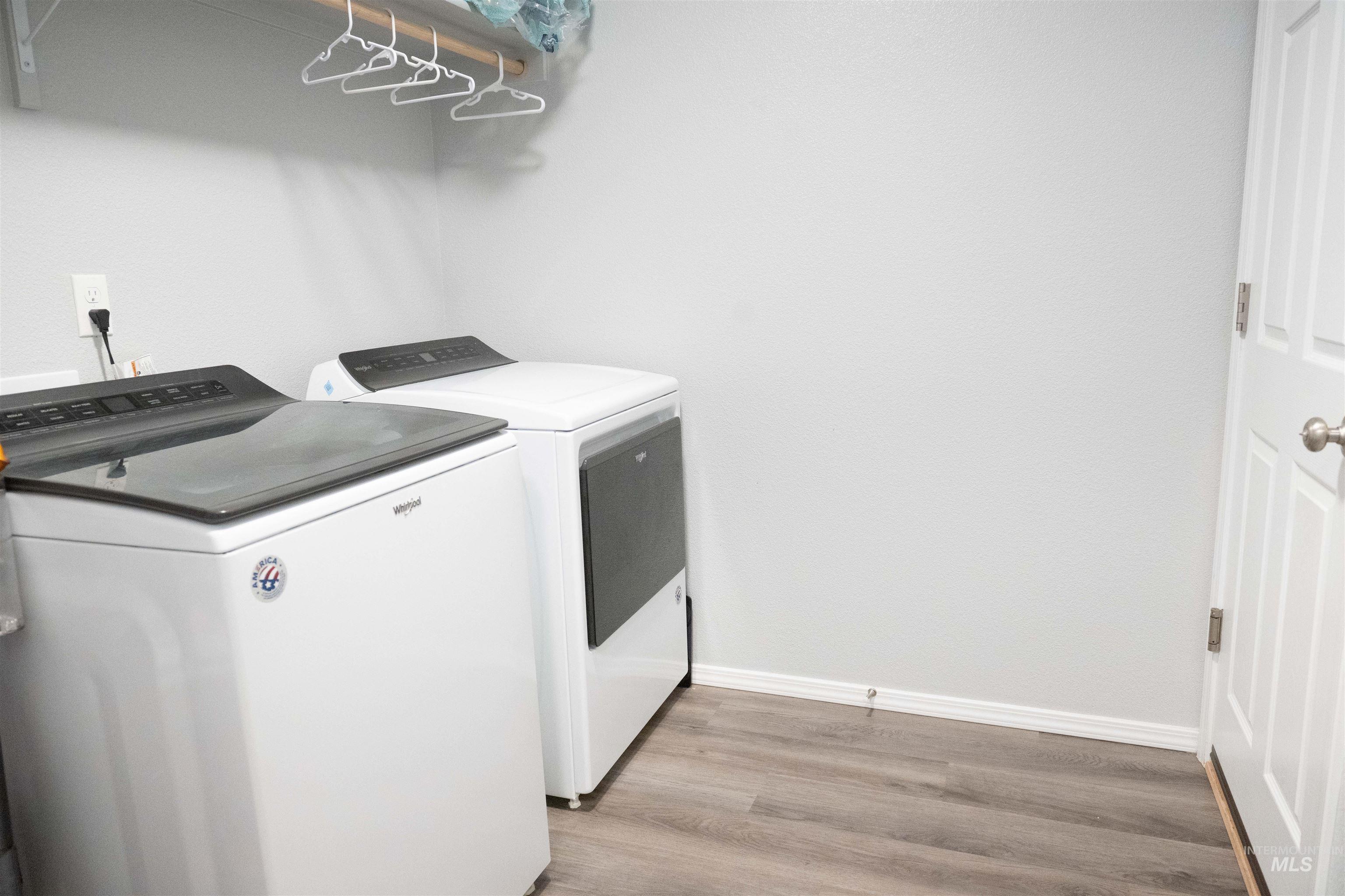 Washroom featuring washing machine and dryer and light wood-style flooring