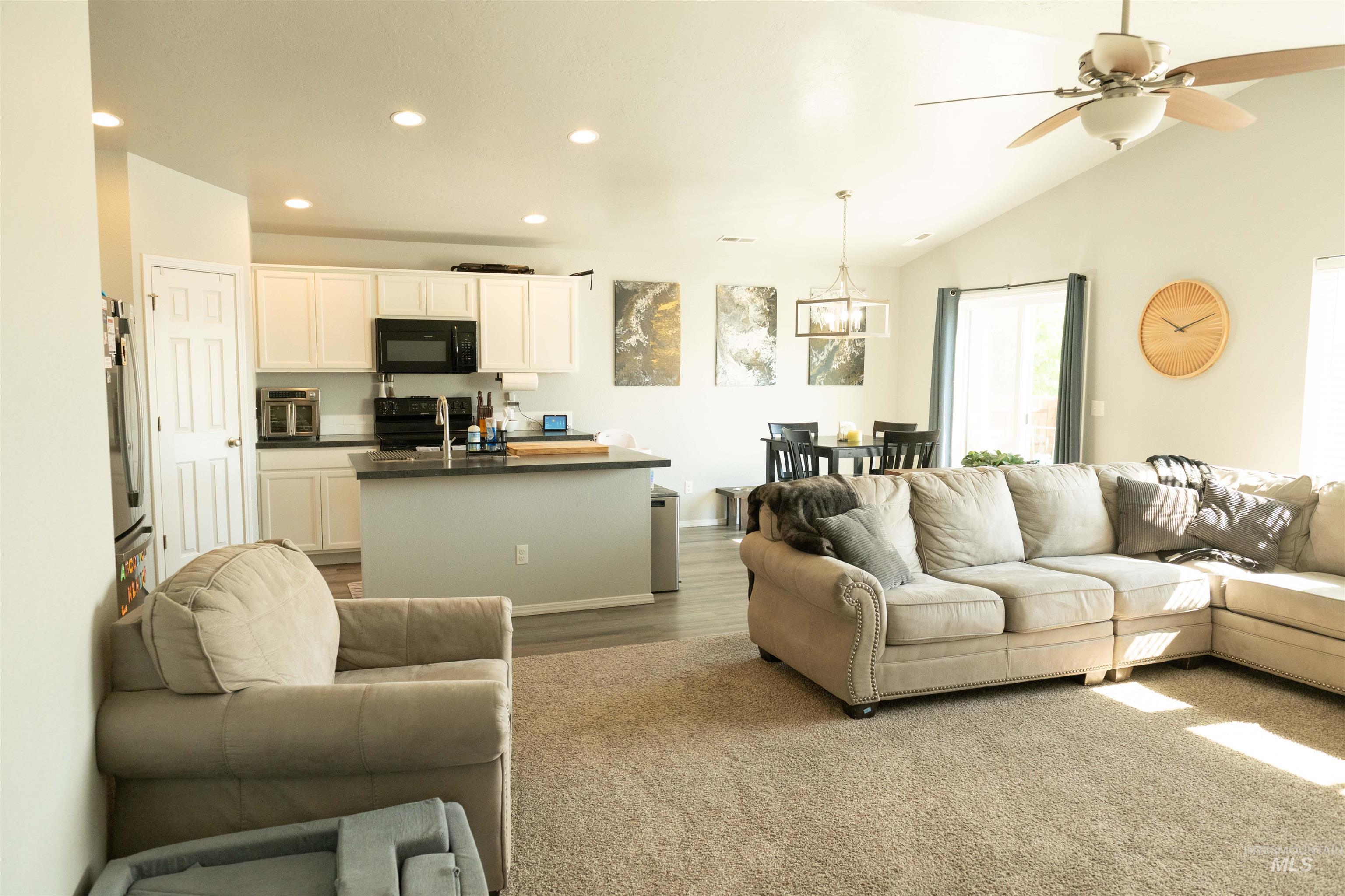 Living room featuring recessed lighting, vaulted ceiling, a ceiling fan, and wood finished floors