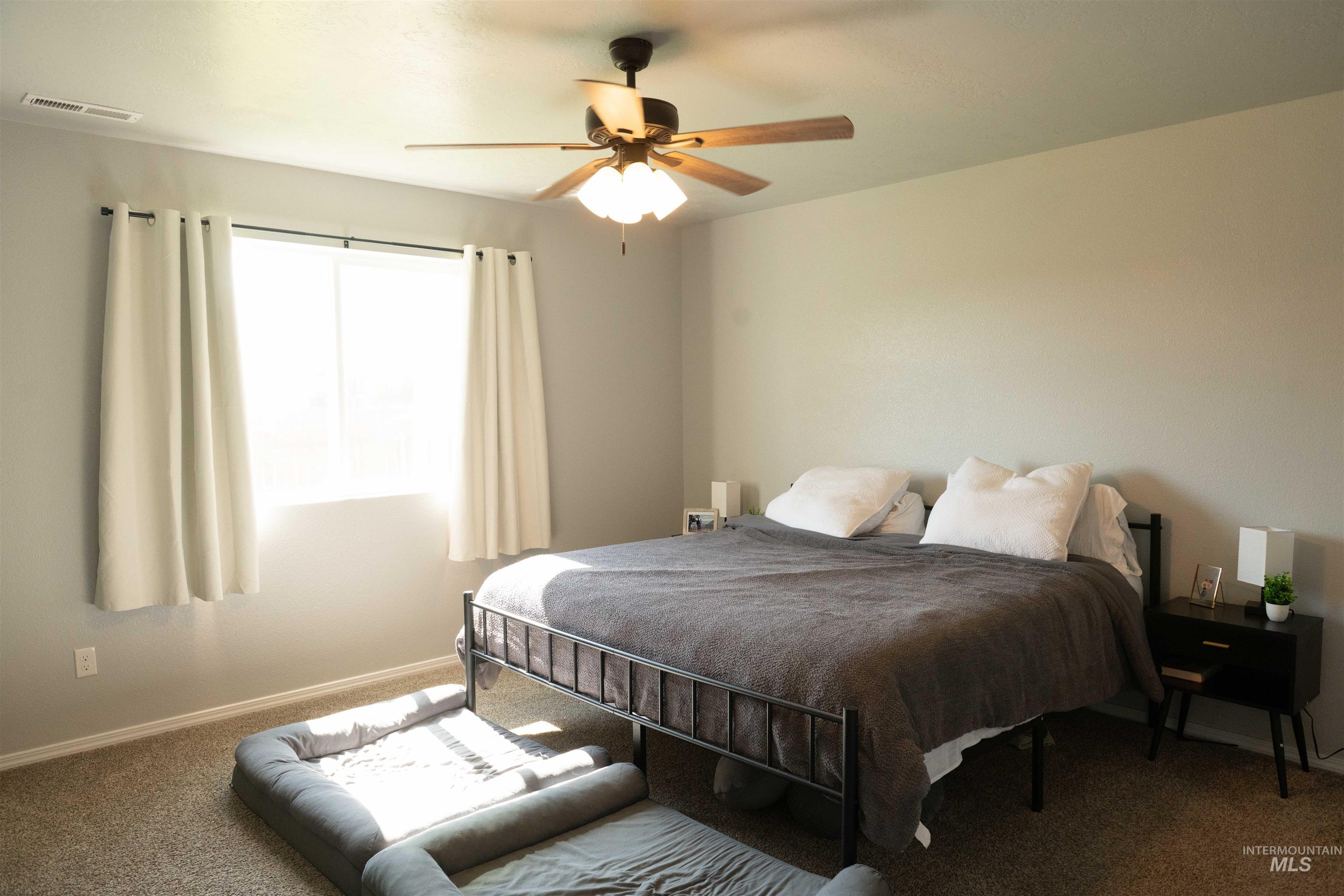 Carpeted bedroom with baseboards and a ceiling fan