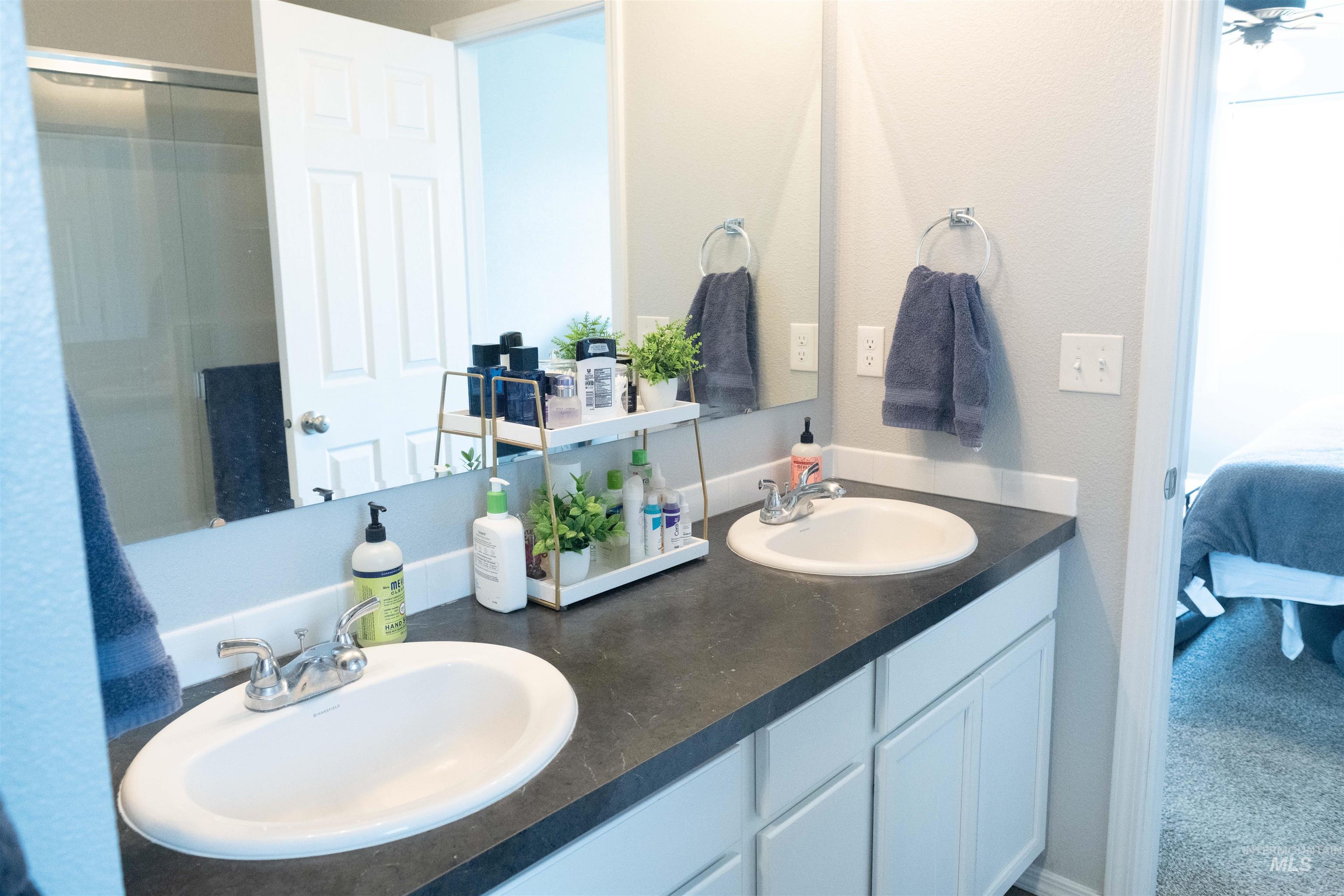 Bathroom featuring double vanity and ensuite bathroom