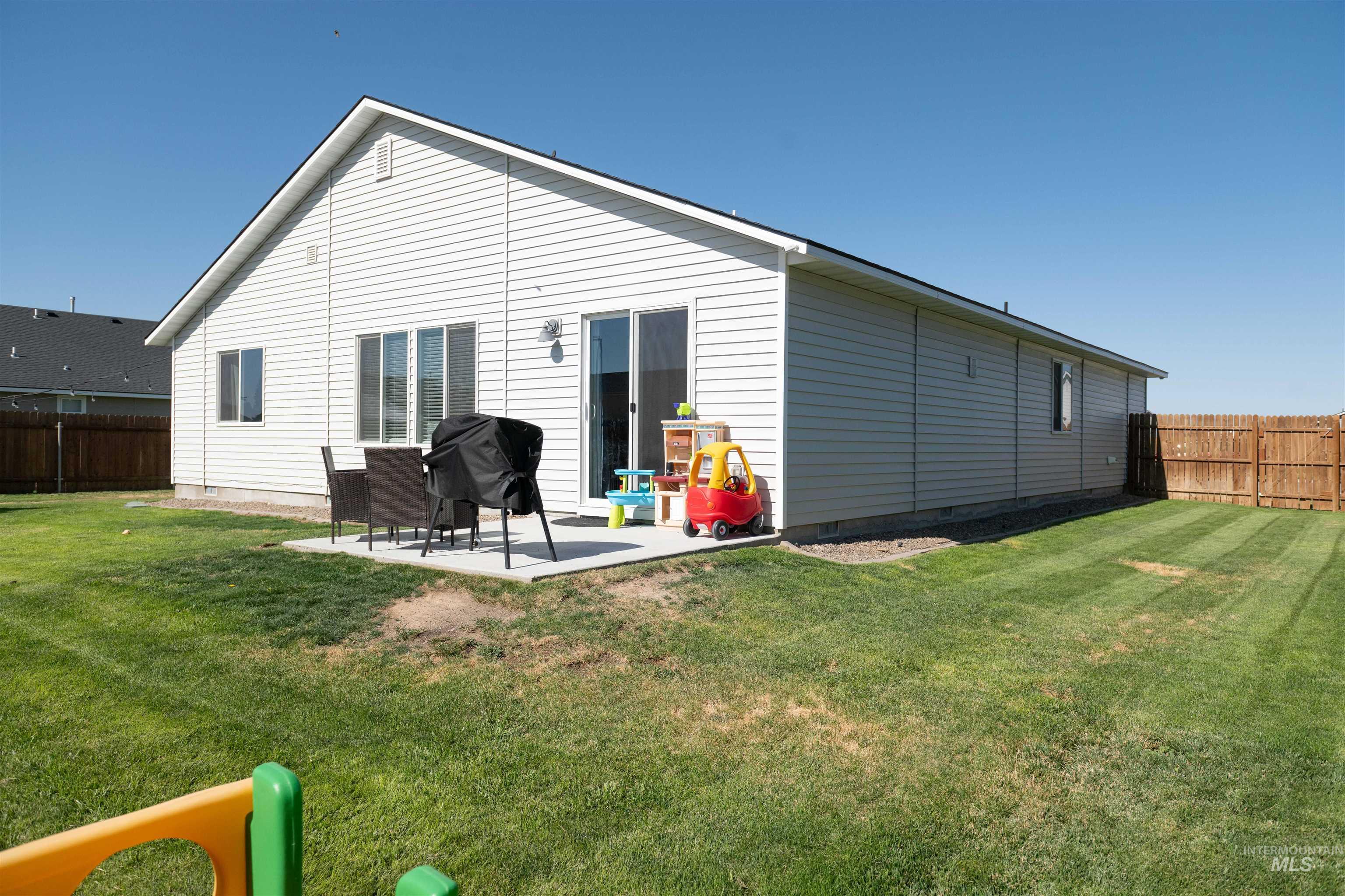 Back of house with crawl space, a fenced backyard, and a patio