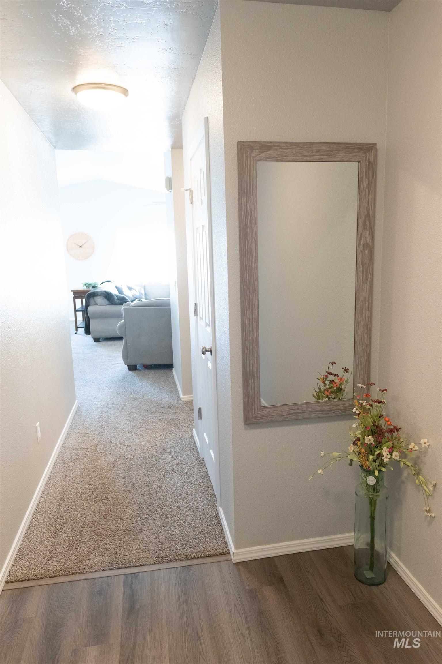 Hallway with wood finished floors and a textured ceiling