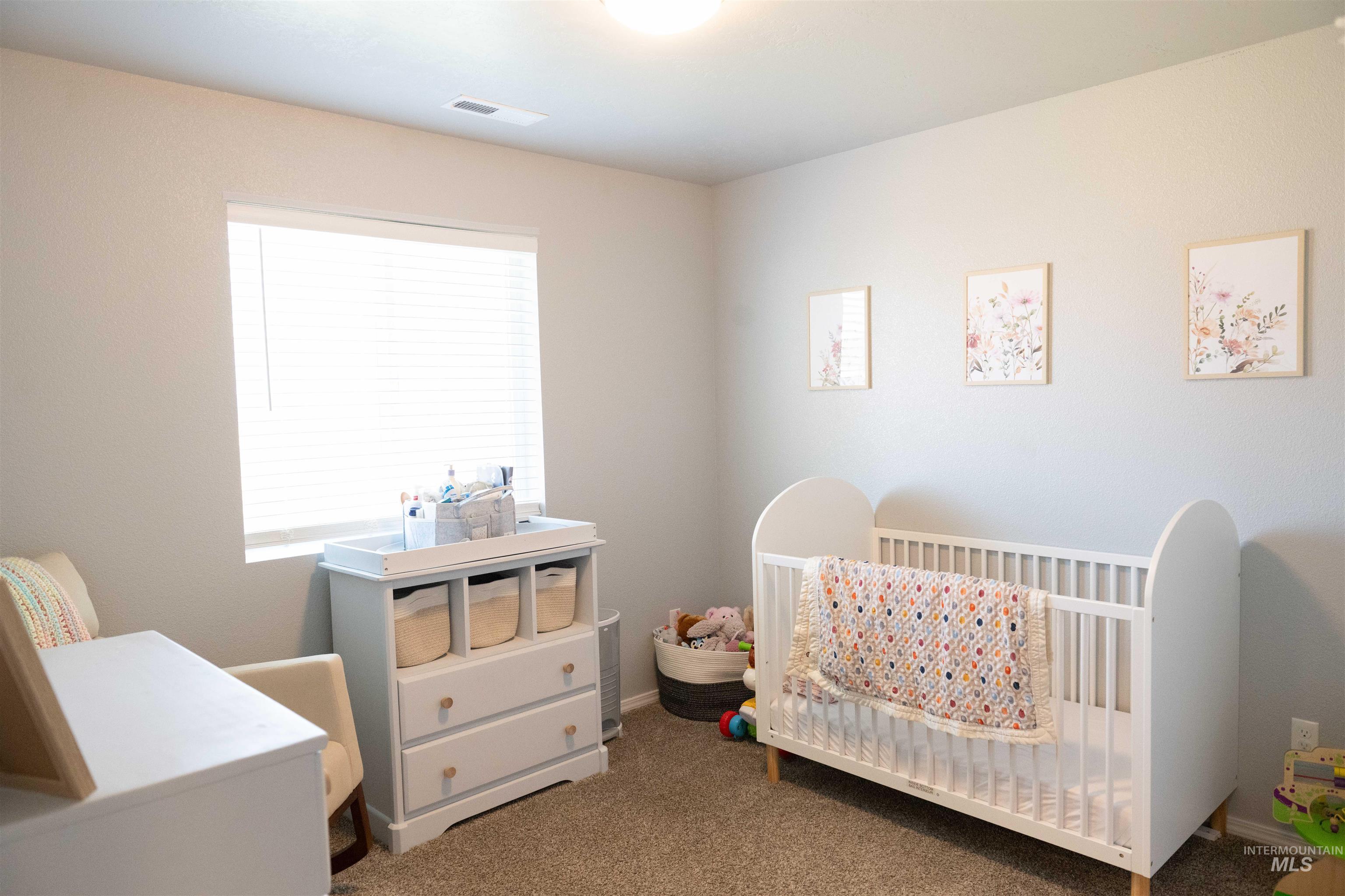 Bedroom with carpet flooring and a crib