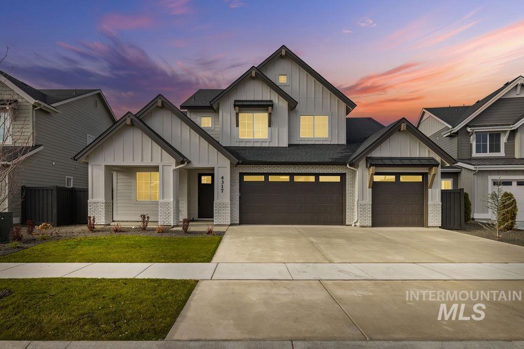View of front of house with board and batten siding, concrete driveway, a garage, and a shingled roof