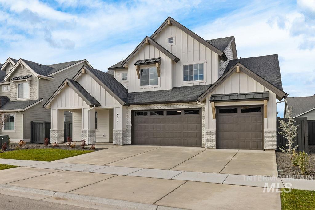 Modern farmhouse featuring board and batten siding, driveway, roof with shingles, and an attached garage