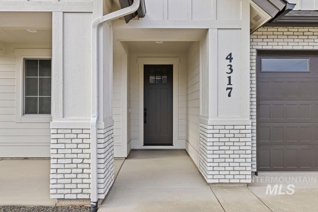 Doorway to property featuring brick siding
